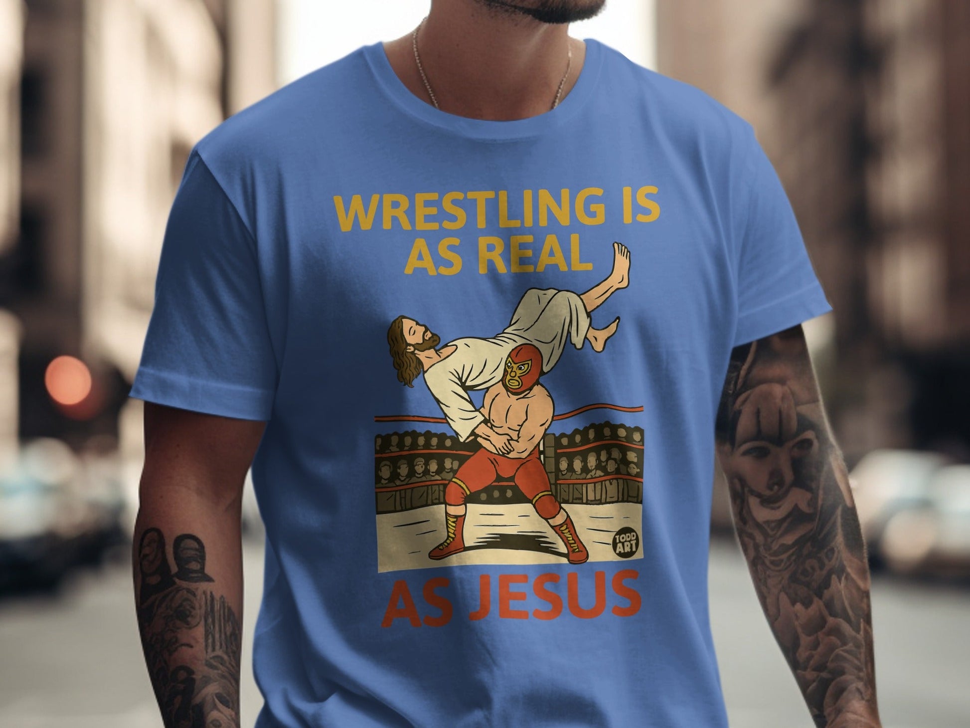 Wrestling is real, as Jesus, graphic on a blue t-shirt.