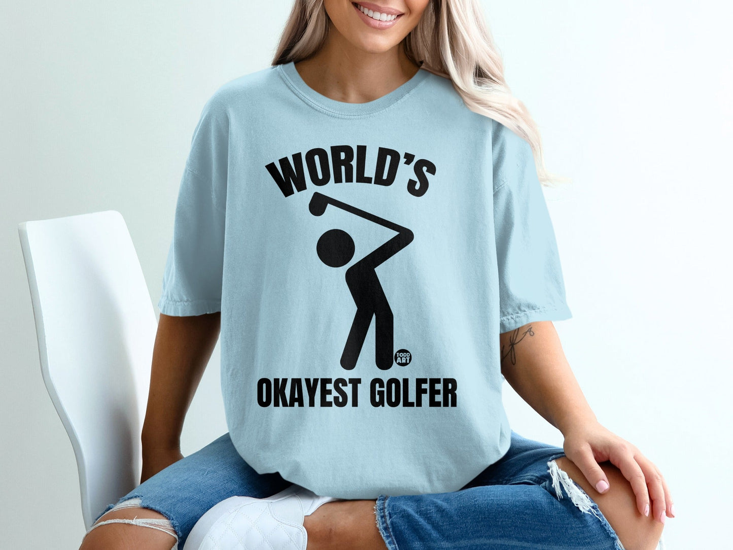 Light blue t-shirt with black text and graphic of a golfer.