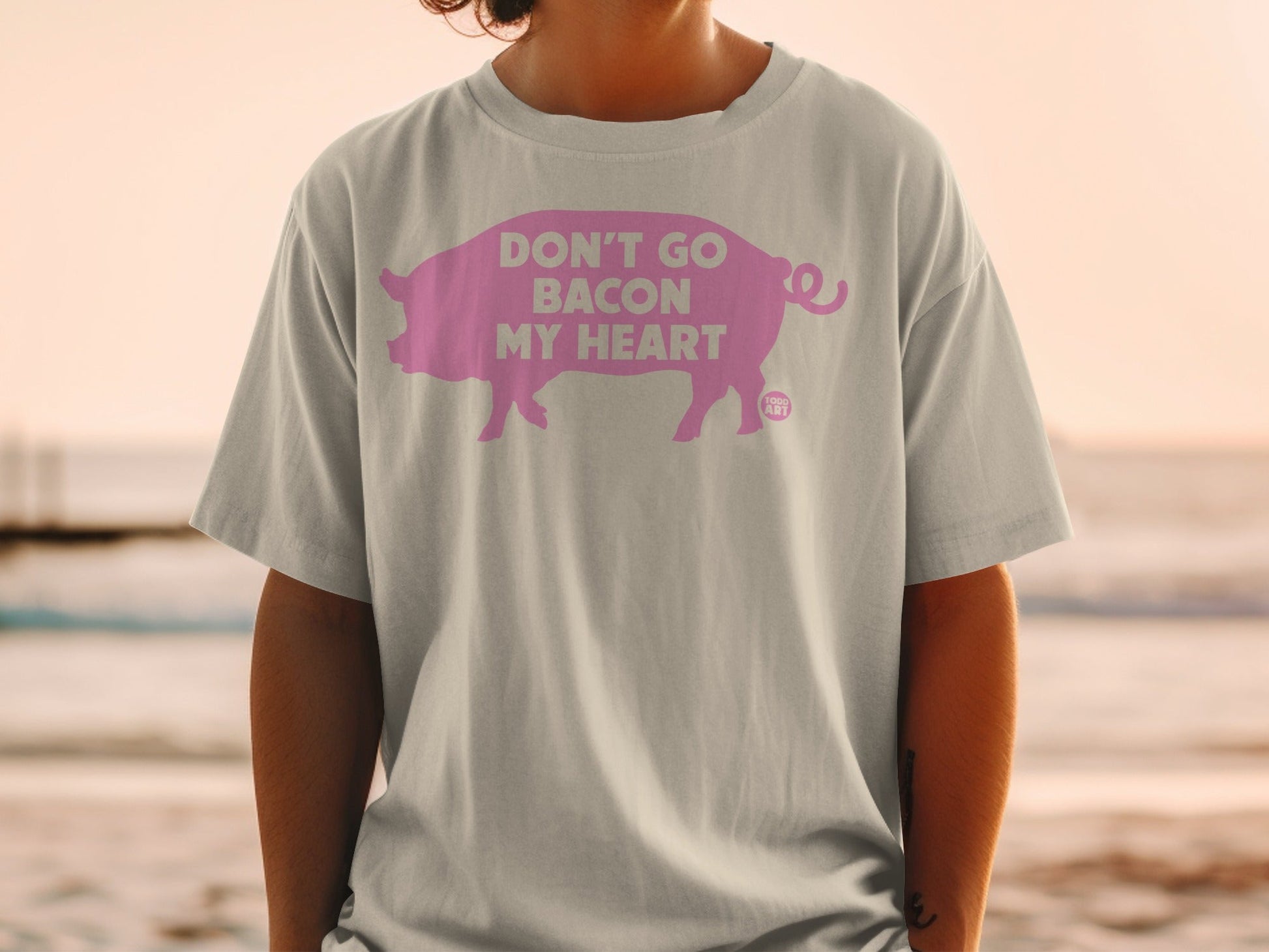 Grey t-shirt with pink pig graphic and text "Don't Go Bacon My Heart".