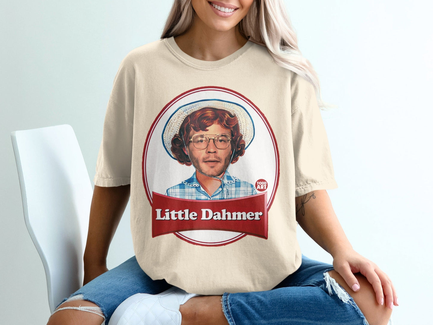 Cream t-shirt with red circle graphic featuring "Little Dahmer" and a portrait of a person.