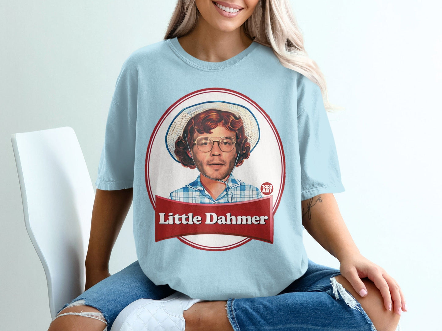 Light blue t-shirt featuring a cartoon portrait of a man in a hat, text "Little Dahmer".