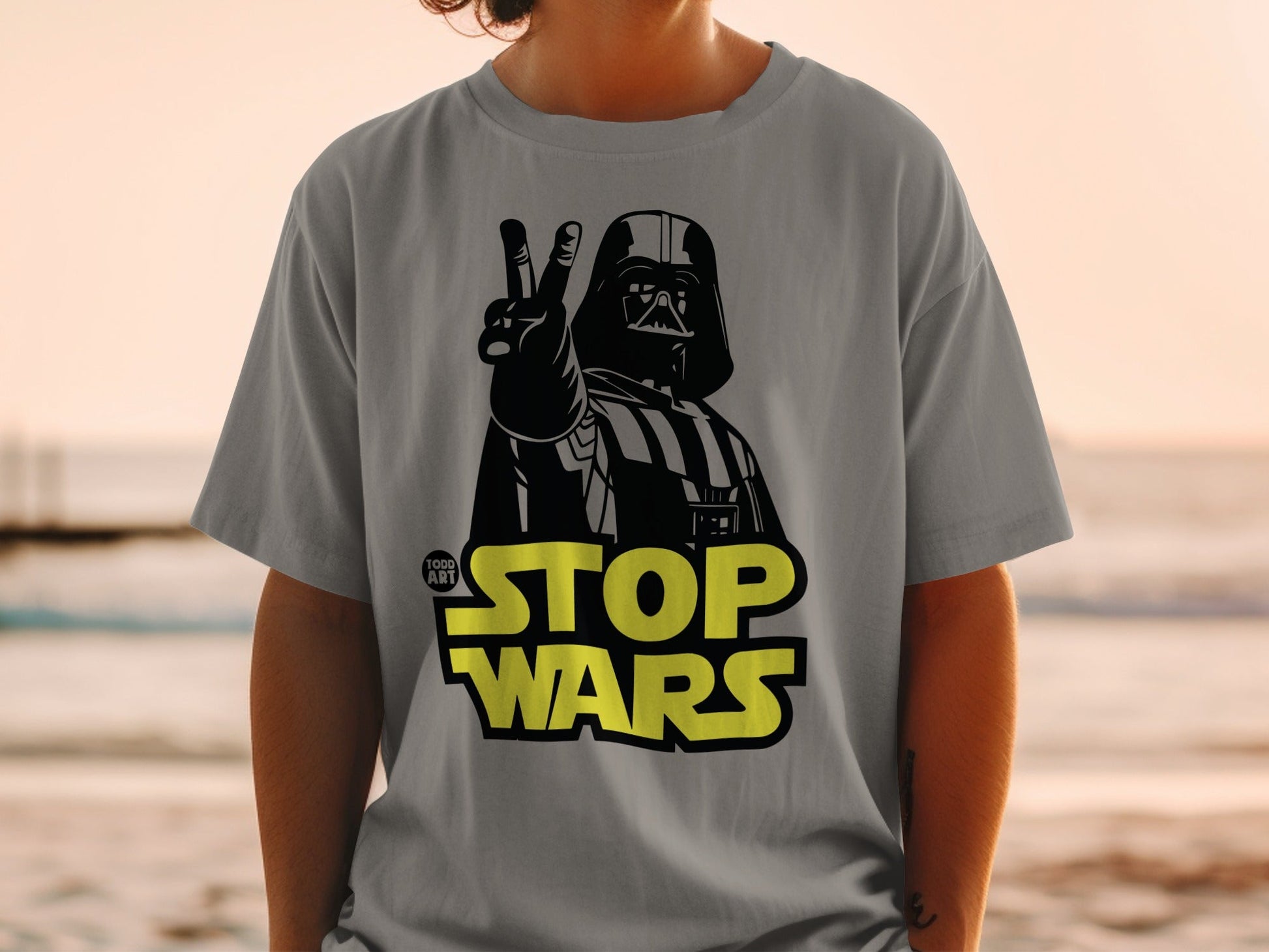Grey t-shirt with Darth Vader giving peace sign and "STOP WARS" text.
