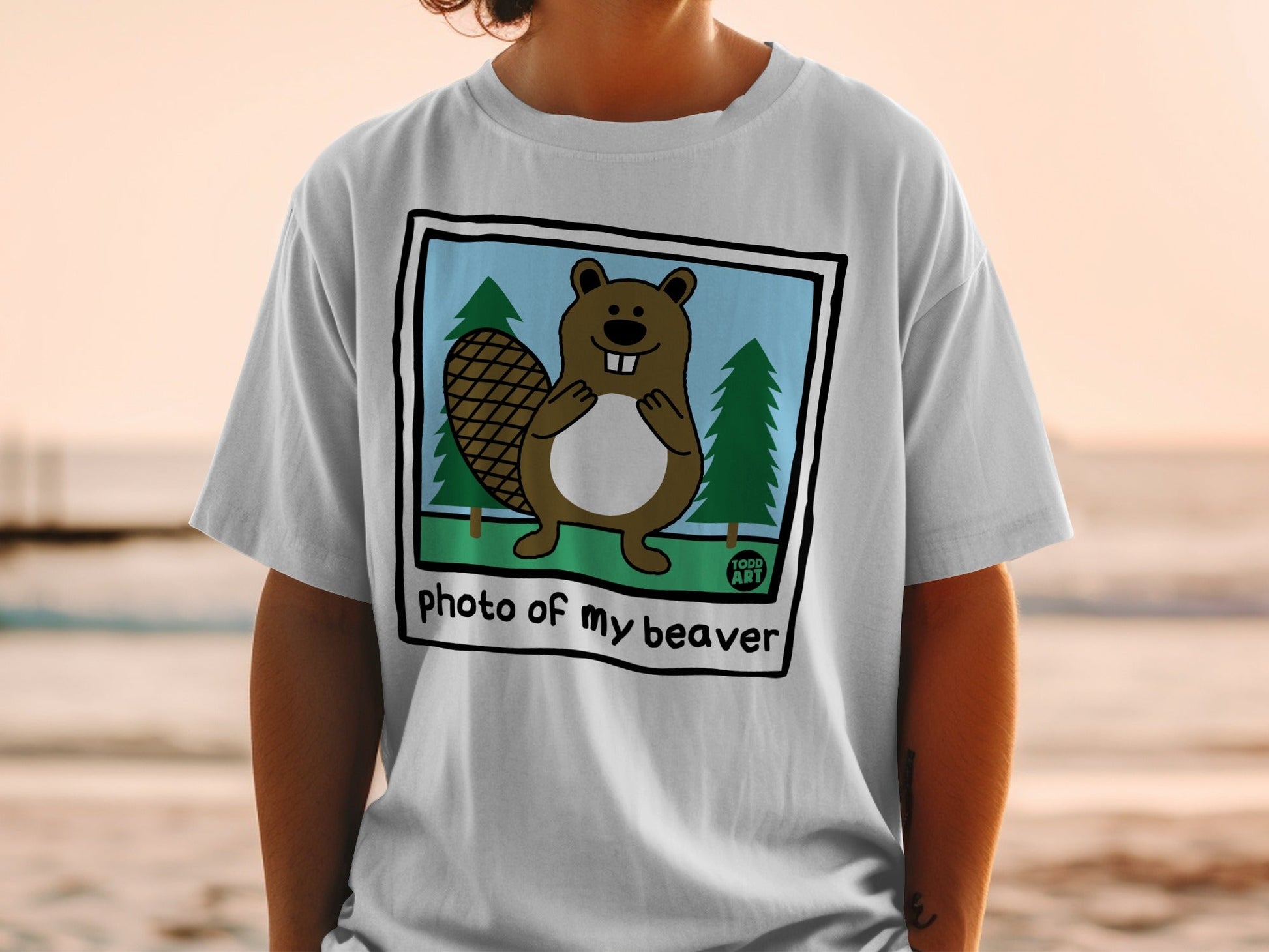 White t-shirt with cartoon beaver and trees, text "photo of my beaver"