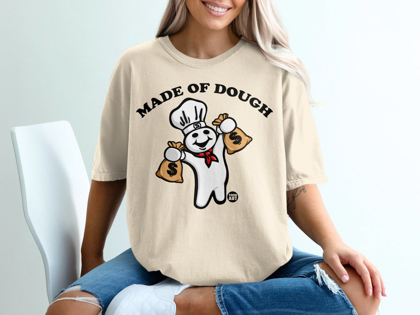 Pillsbury Doughboy wearing chef hat holding money bags, "MADE OF DOUGH" text.
