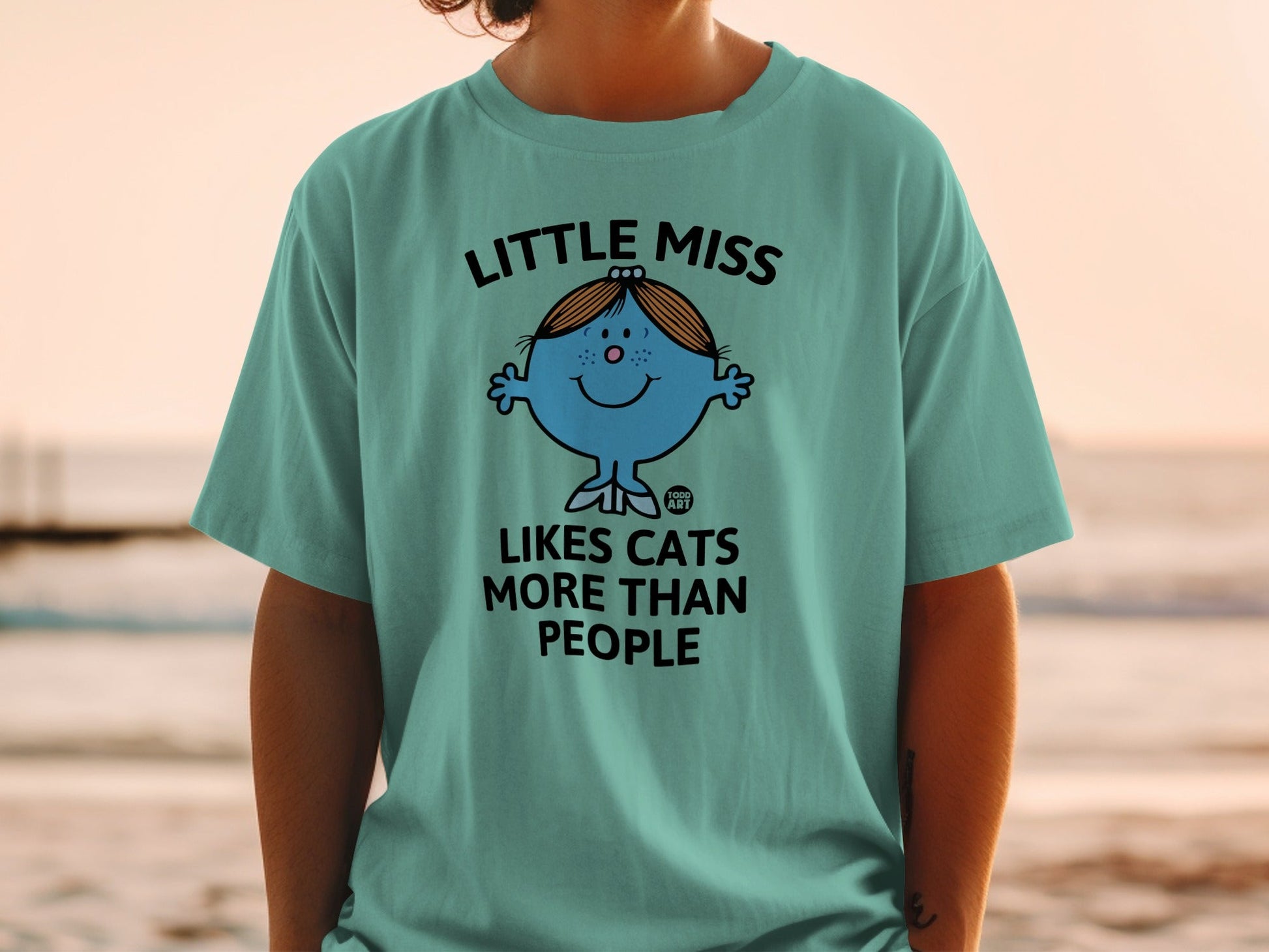 Teal t-shirt with "Little Miss Likes Cats More Than People" text and cartoon character.