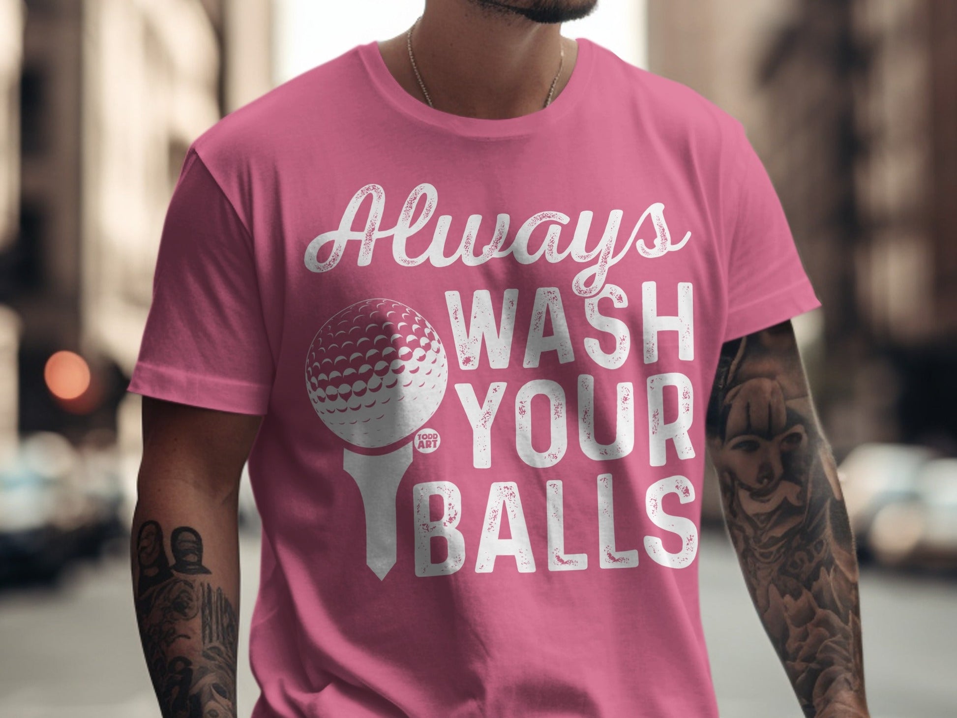 Pink t-shirt with white text "Always Wash Your Balls" and golf ball graphic.