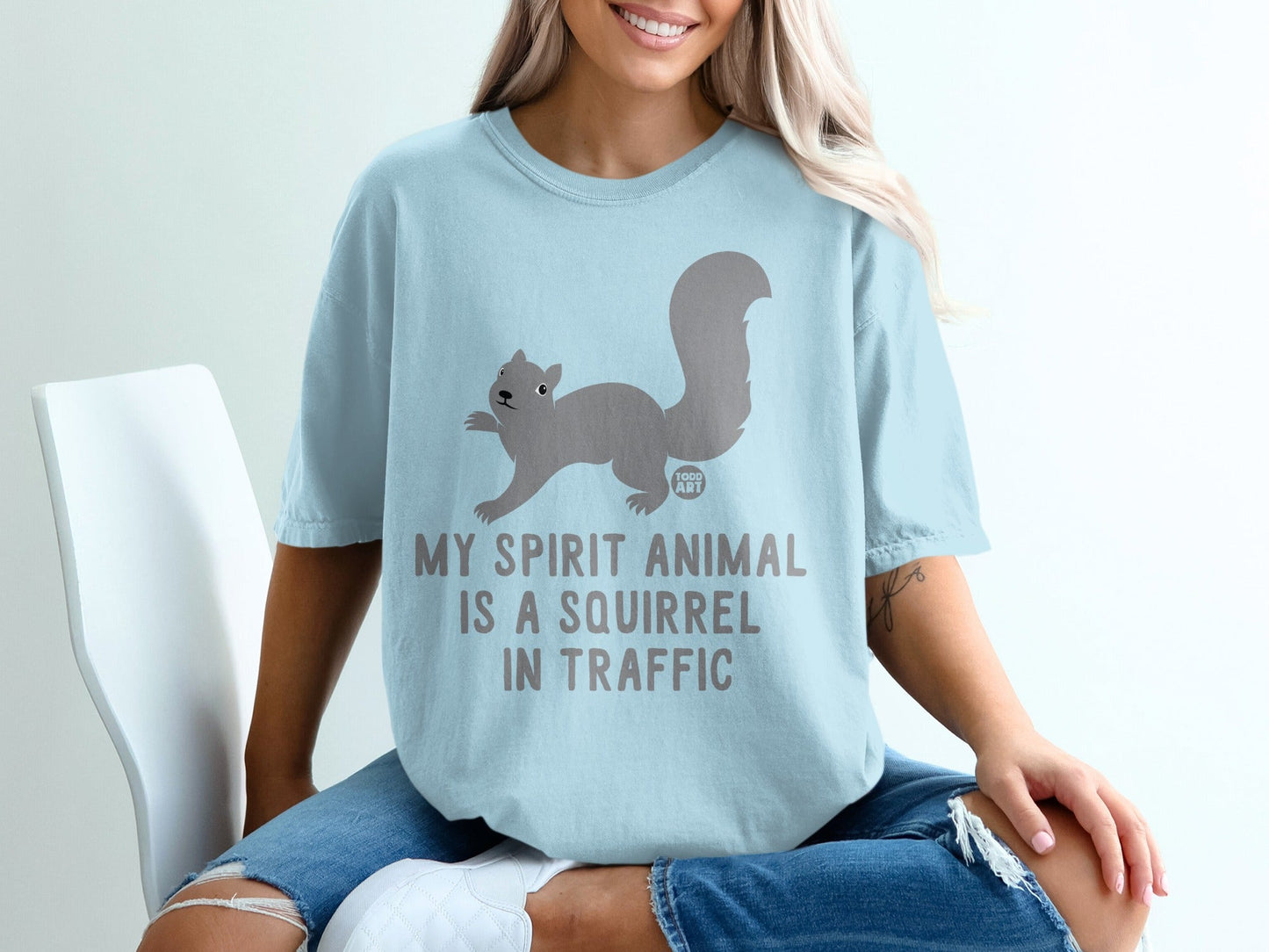 Light blue t-shirt with a squirrel graphic and text "MY SPIRIT ANIMAL IS A SQUIRREL IN TRAFFIC".