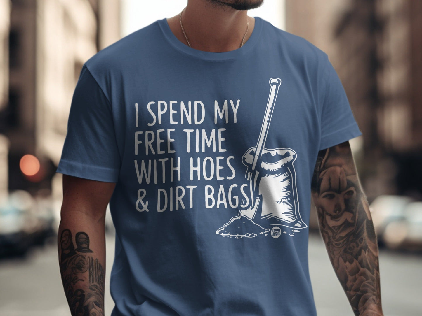 Blue t-shirt with "I spend my free time with hoes & dirt bags" and shovel graphic.