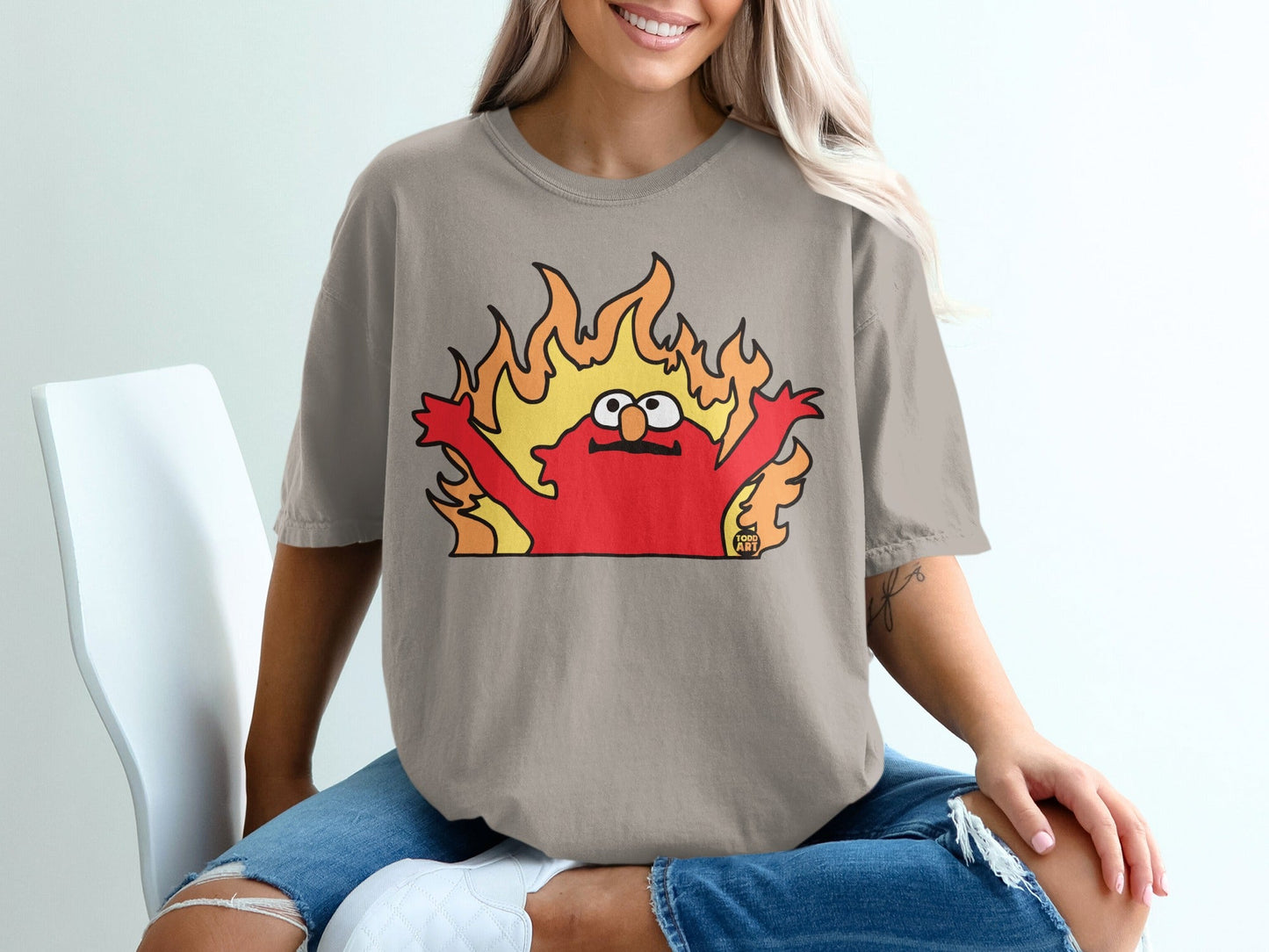 Elmo t-shirt with flames behind him and a small cat logo on the left.