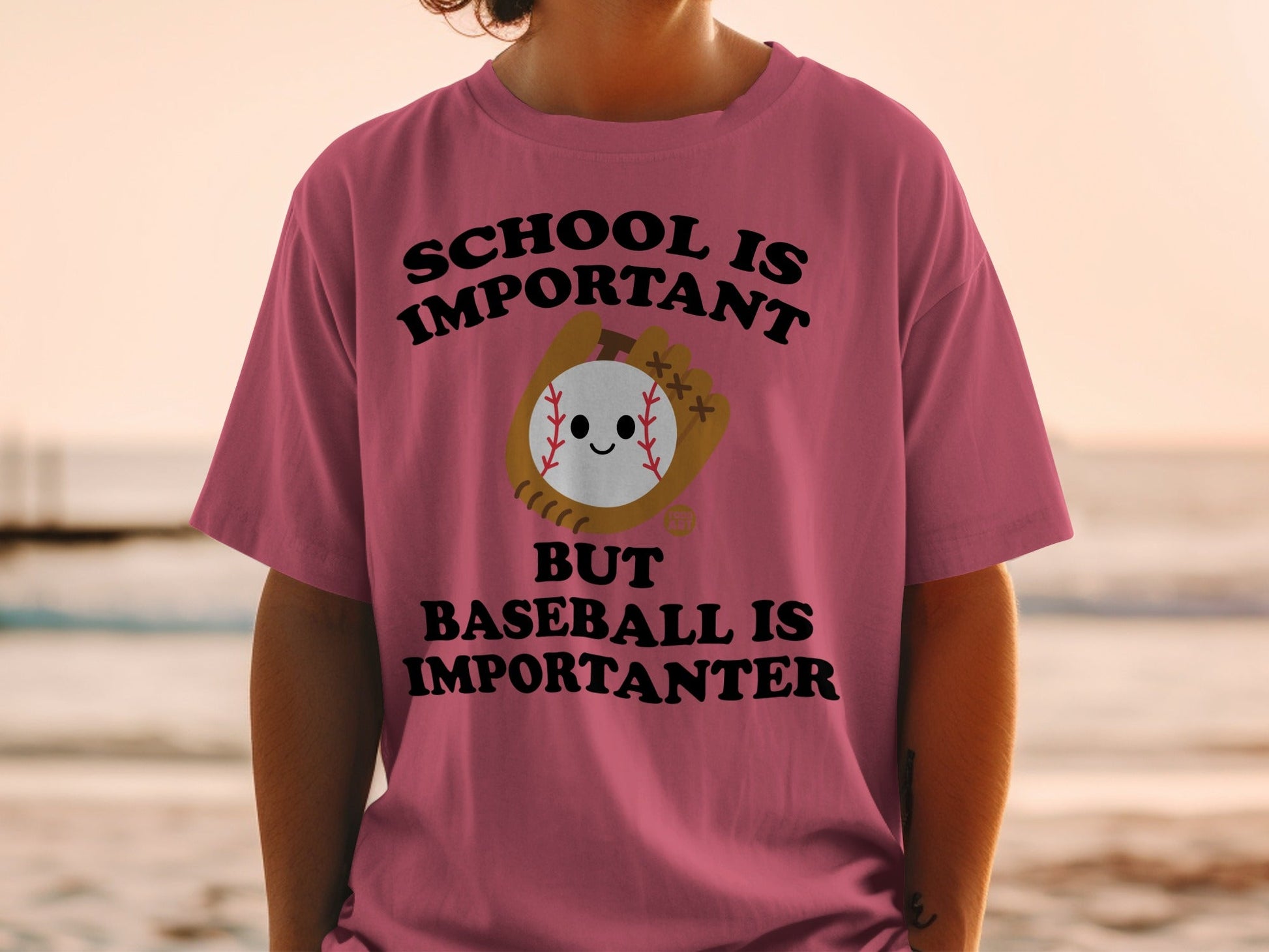 Pink t-shirt with text: SCHOOL IS IMPORTANT BUT BASEBALL IS IMPORTANTER.