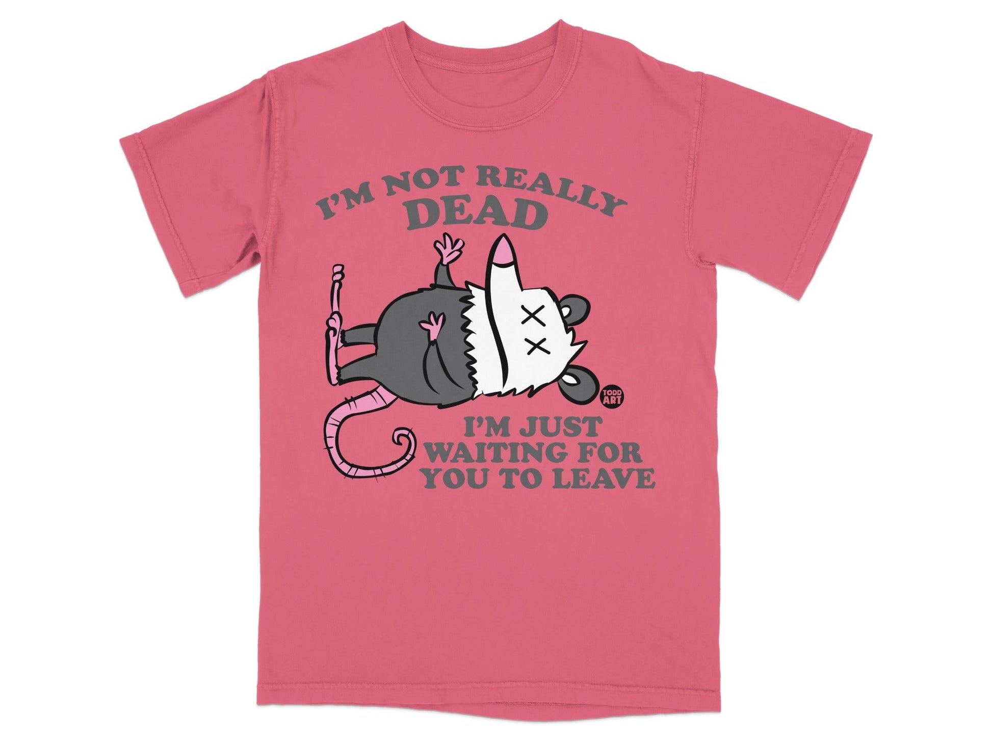 Pink t-shirt with a cartoon opossum playing dead and text "I'M NOT REALLY DEAD I'M JUST WAITING FOR YOU TO LEAVE".