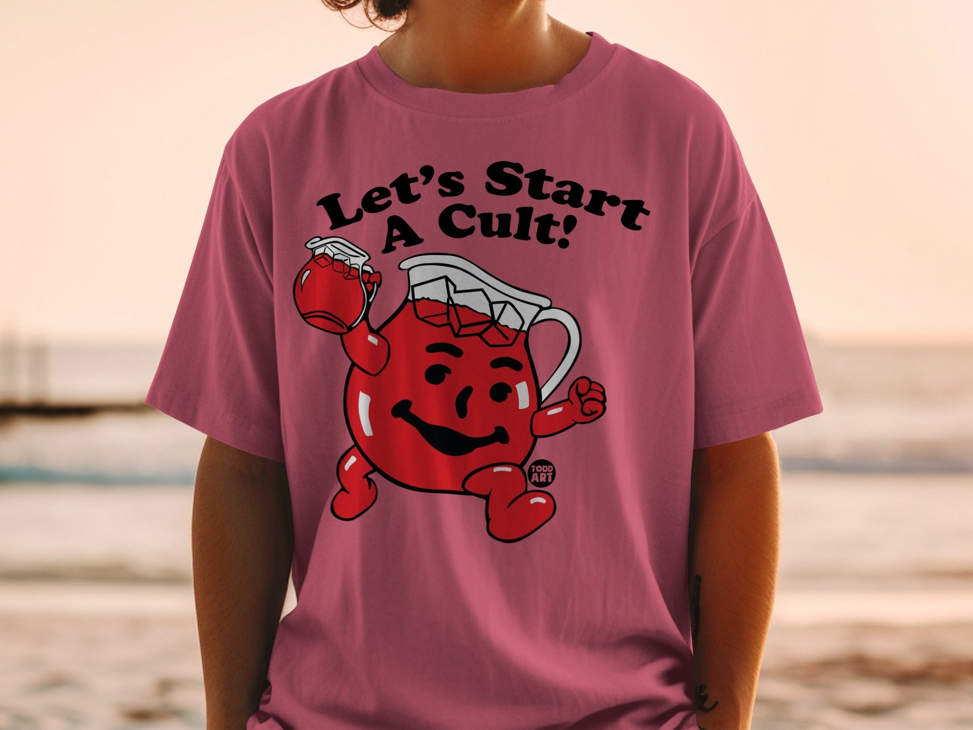 Kool-Aid Man character on pink t-shirt saying "Let's Start A Cult!"