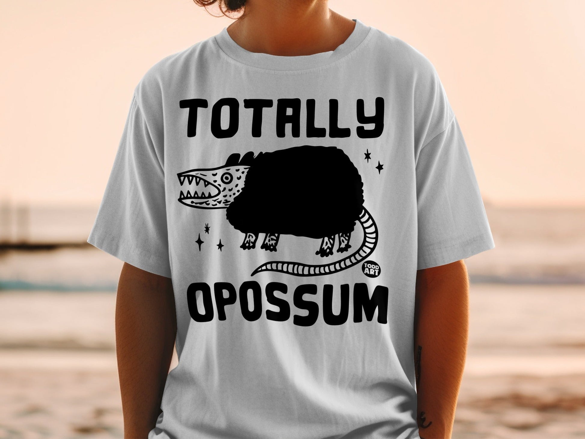 Black graphic t-shirt with "TOTALLY OPOSSUM" text and cartoon opossum design.