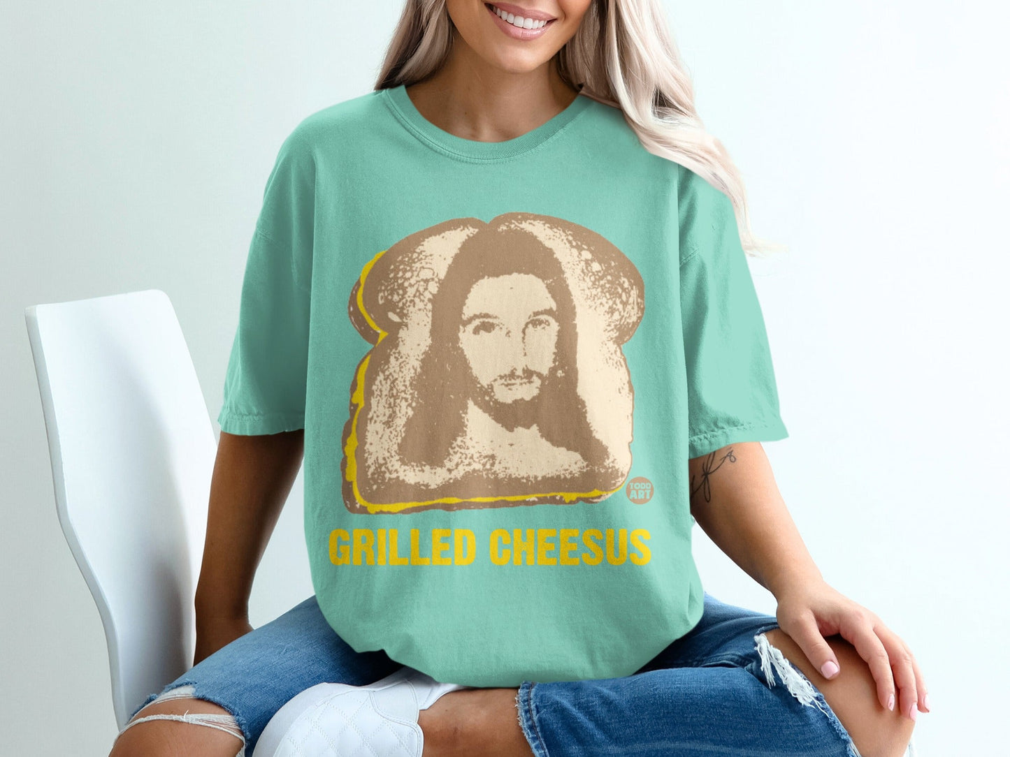 Teal t-shirt with grilled cheese sandwich image and "GRILLED CHEESUS" text.