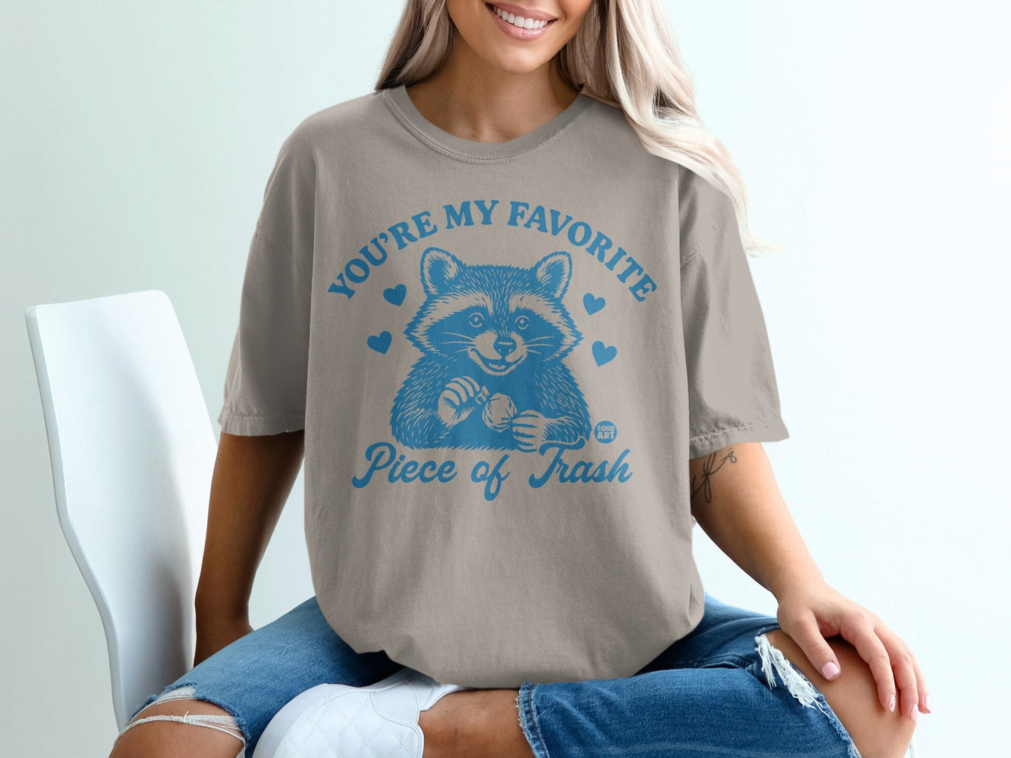 T-shirt with raccoon graphic and text "YOU'RE MY FAVORITE Piece of Trash".