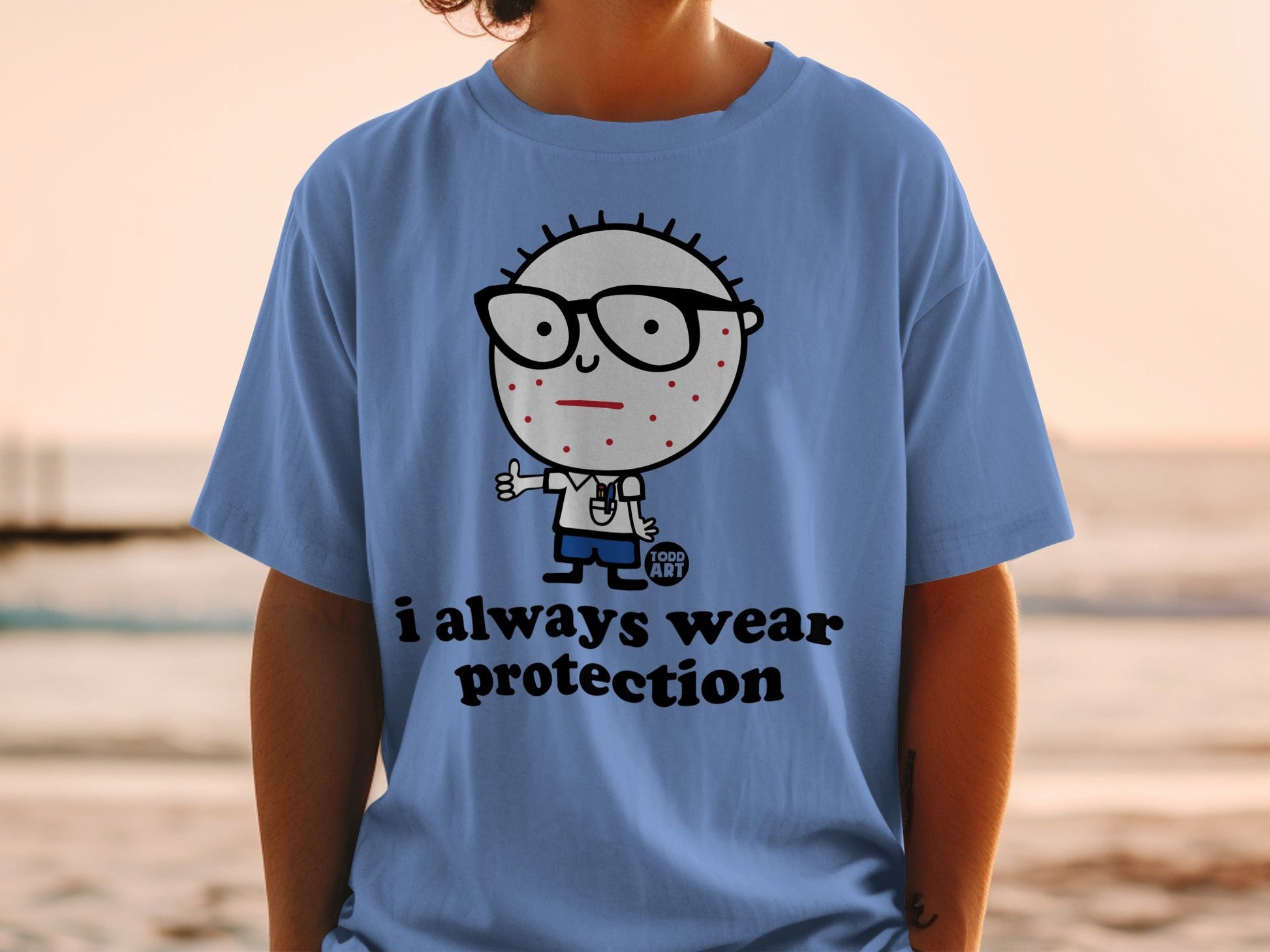 Light blue t-shirt with cartoon character and "i always wear protection" text.
