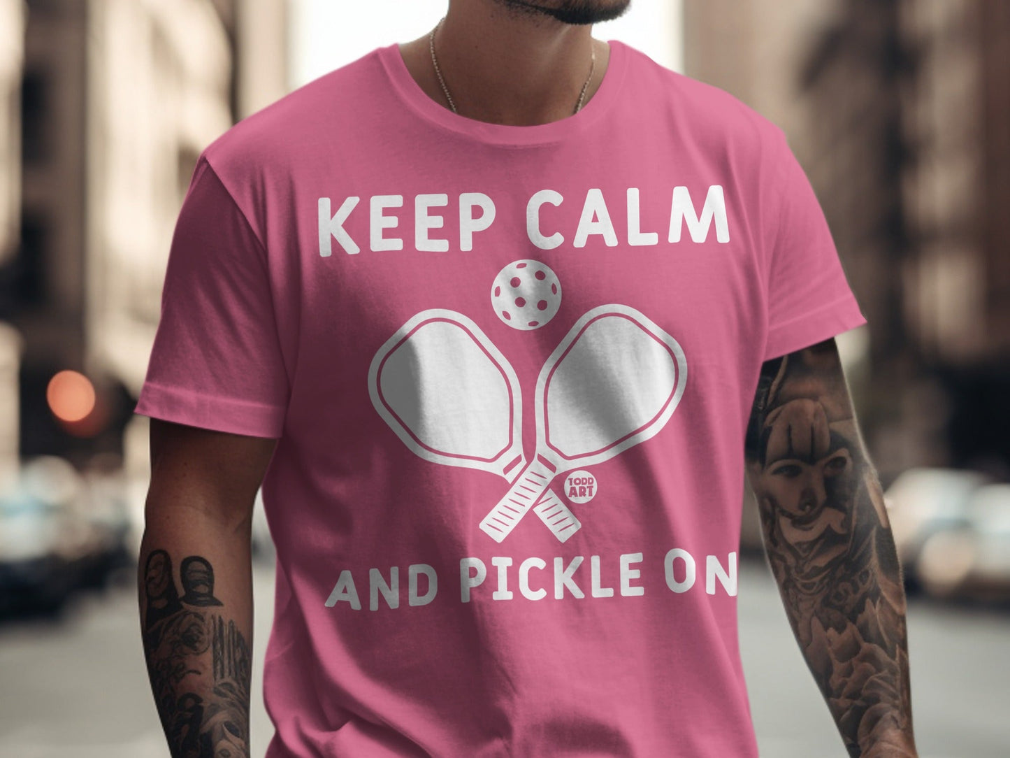 Pink t-shirt with "Keep Calm and Pickle On" text and pickleball paddles.
