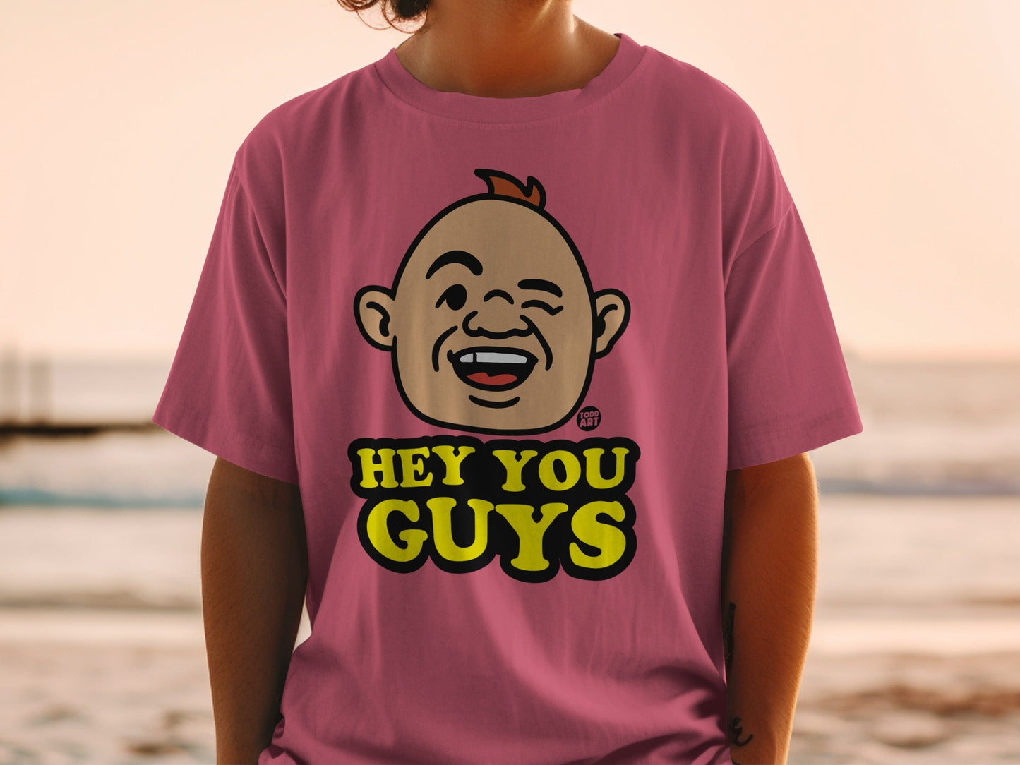Pink t-shirt with a cartoon face and "HEY YOU GUYS" text.