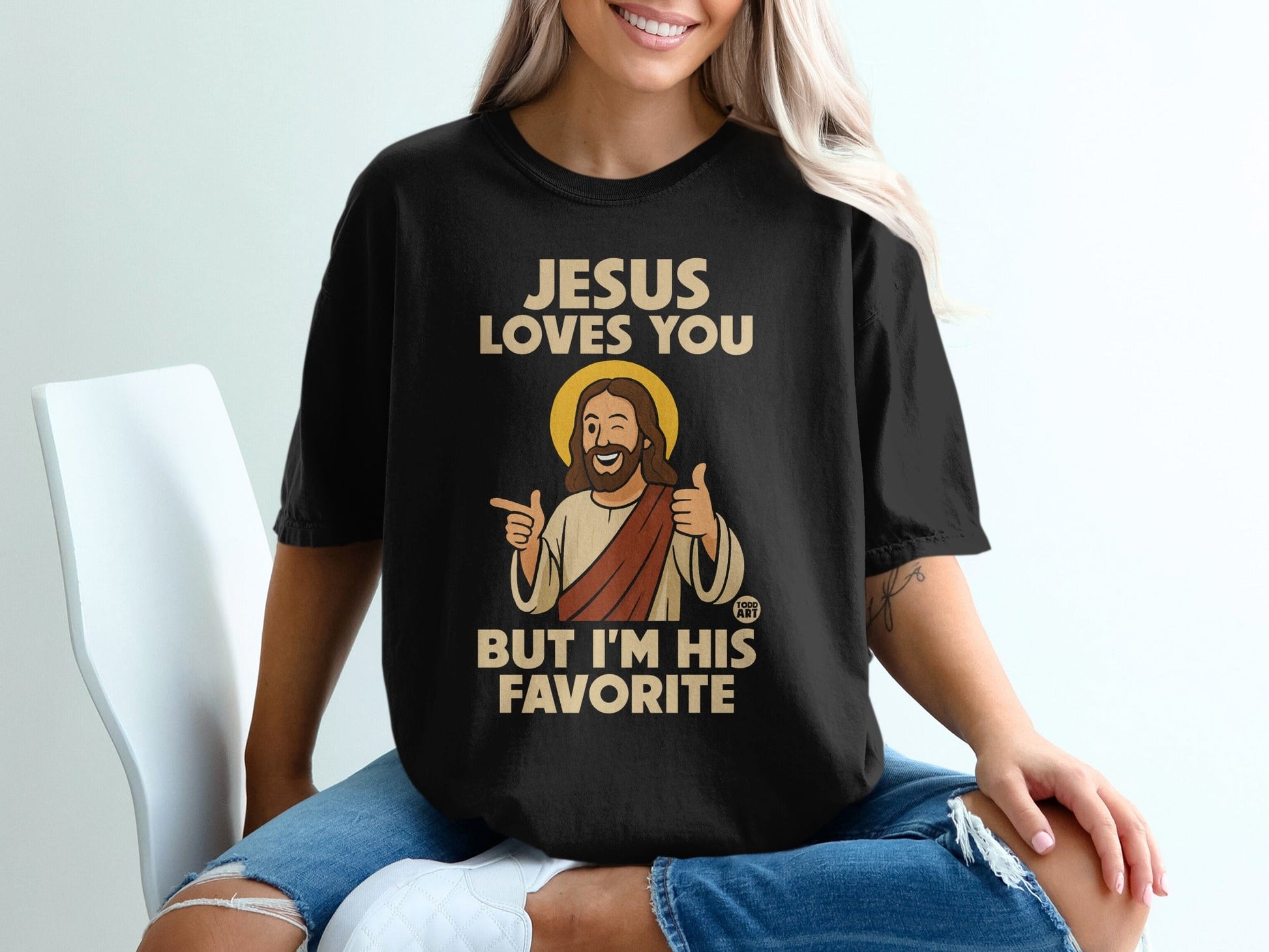 Black t-shirt with "Jesus Loves You But I'm His Favorite" text and cartoon Jesus.