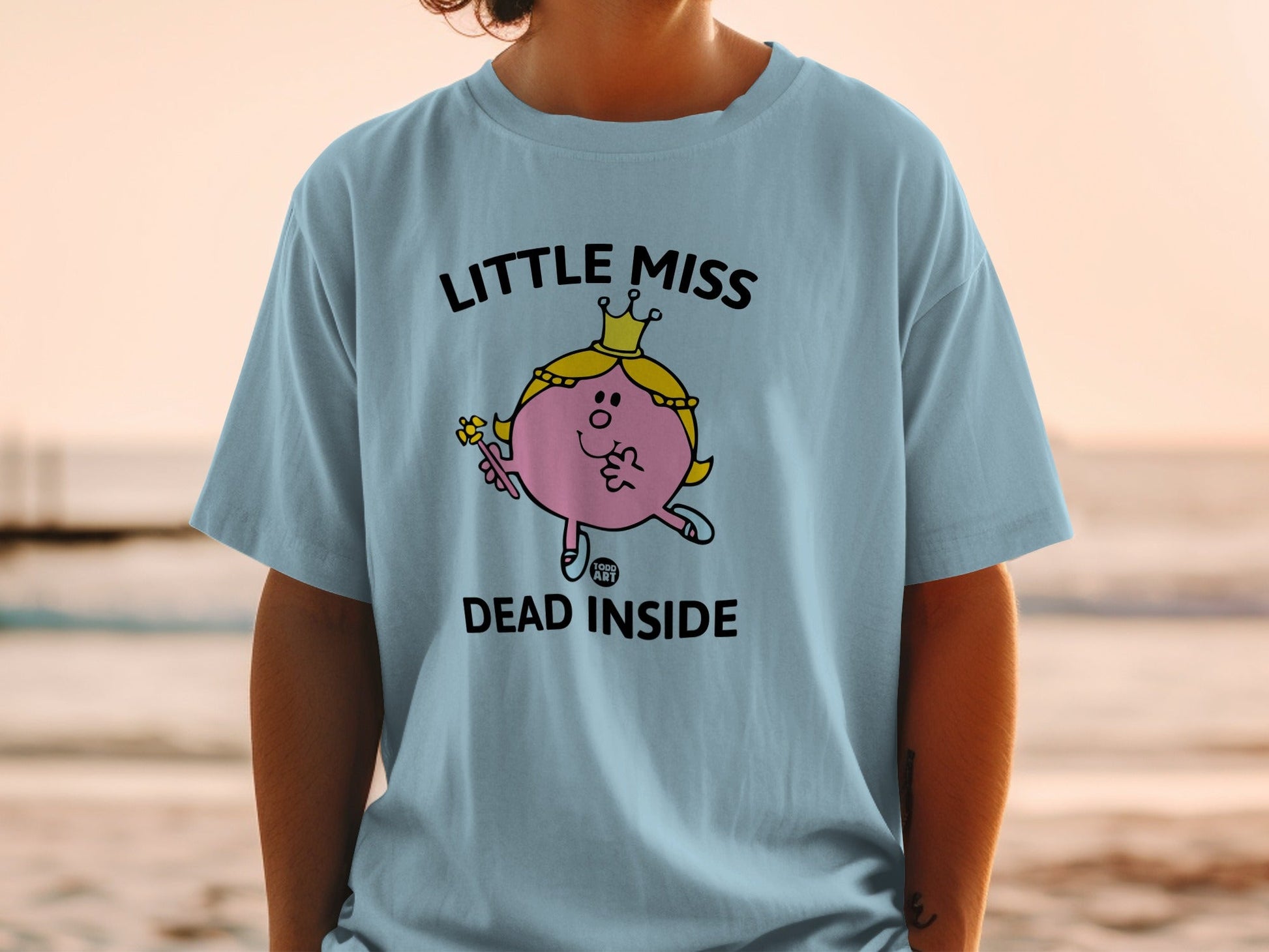 Light blue t-shirt with "Little Miss Dead Inside" text and character.