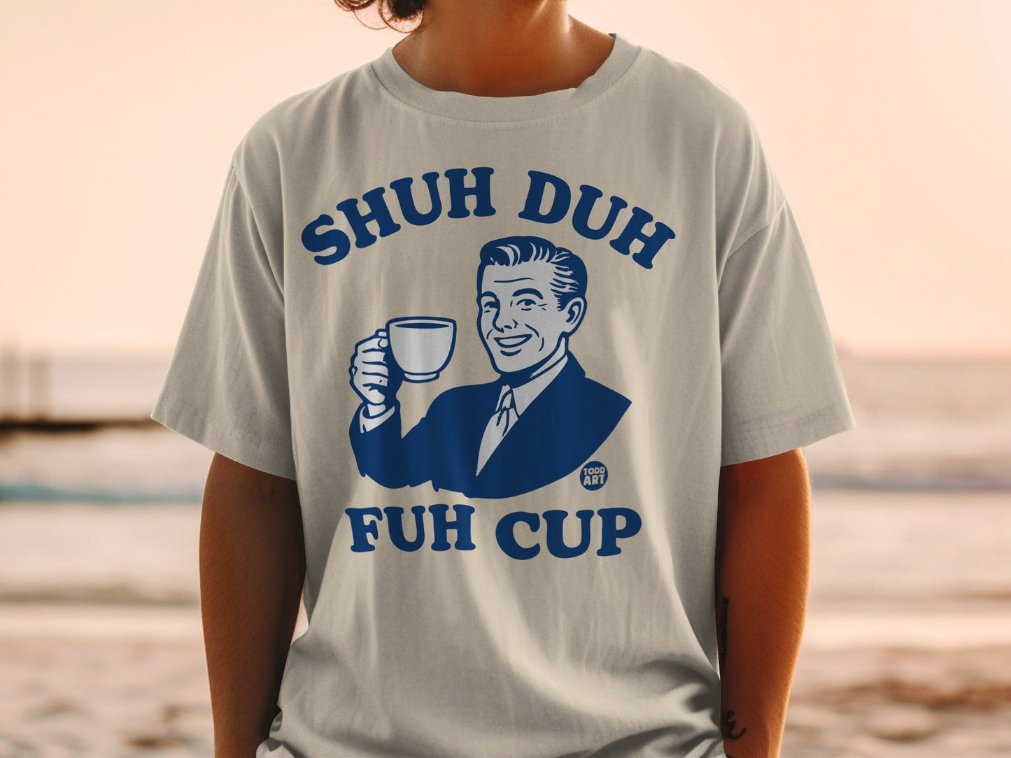 Man in t-shirt holding a coffee cup, "Shuh Duh Fuh Cup" text.
