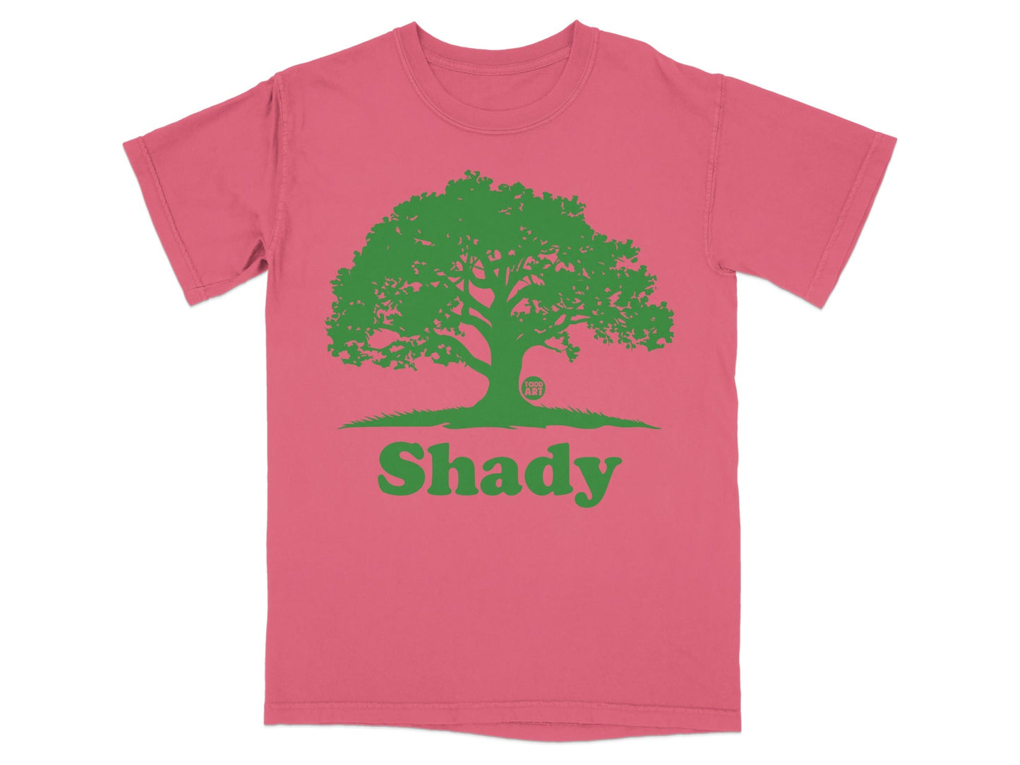 Pink t-shirt with a green silhouette of a tree and the word "Shady".