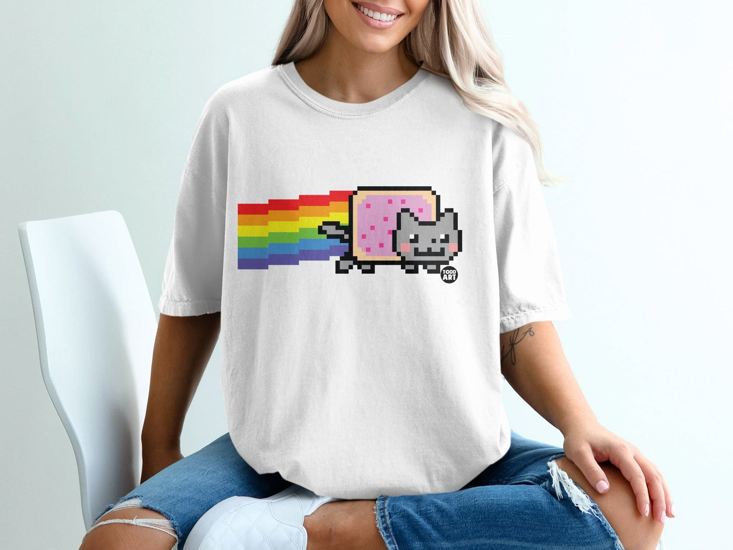 Nyan Cat sprite with rainbow trail on a white t-shirt.
