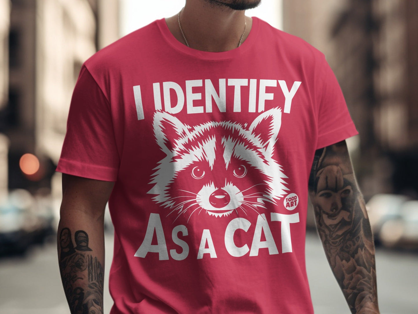 Red t-shirt with "I identify as a cat" text and raccoon graphic.