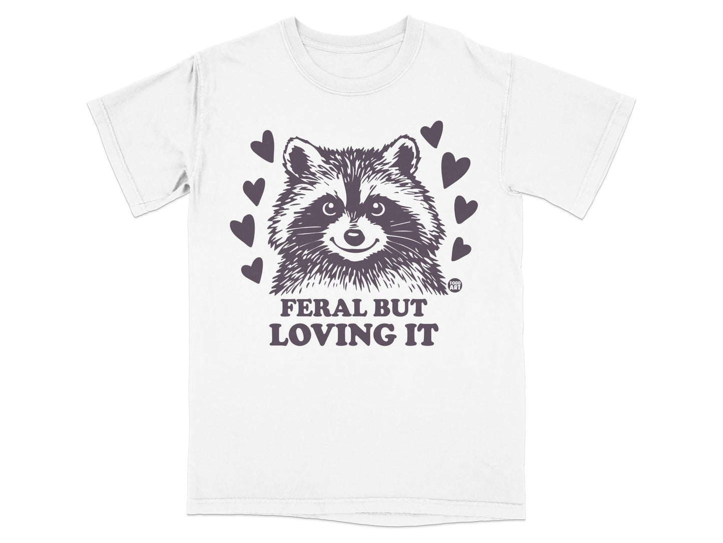 White t-shirt with raccoon graphic and "Feral but loving it" text.