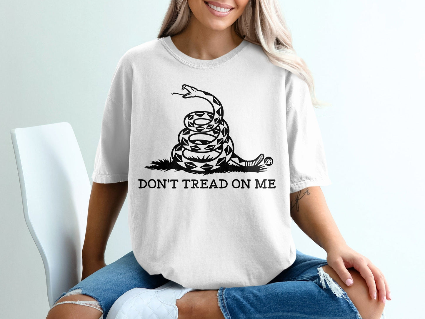 White t-shirt with coiled snake and "DON'T TREAD ON ME" text.
