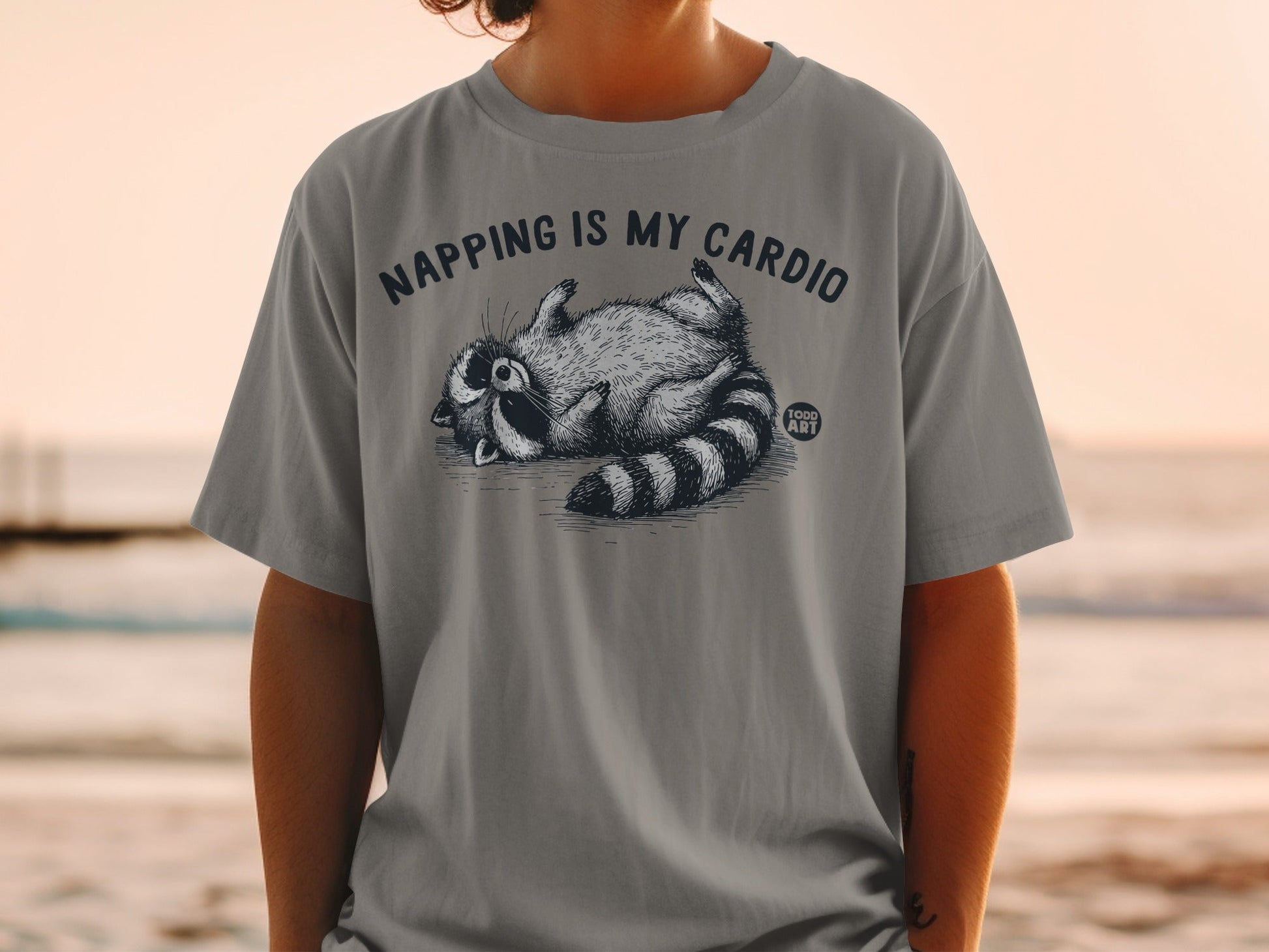 Gray t-shirt with raccoon graphic and "NAPPING IS MY CARDIO" text.