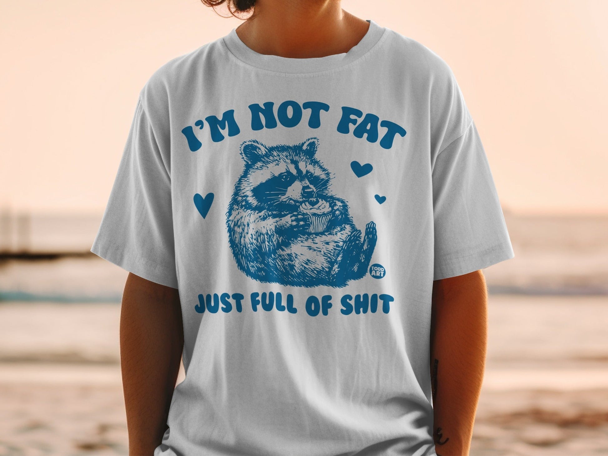 T-shirt with raccoon holding cup and "I'M NOT FAT JUST FULL OF SHIT" text.