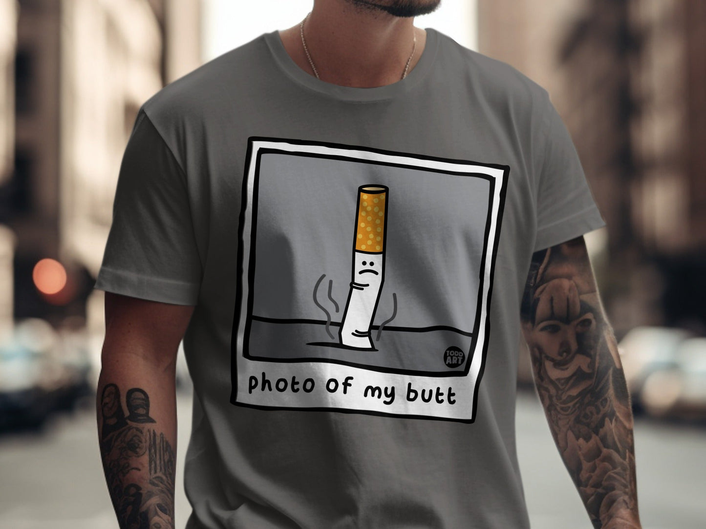 T-shirt featuring cartoon cigarette with sad face and text "photo of my butt".
