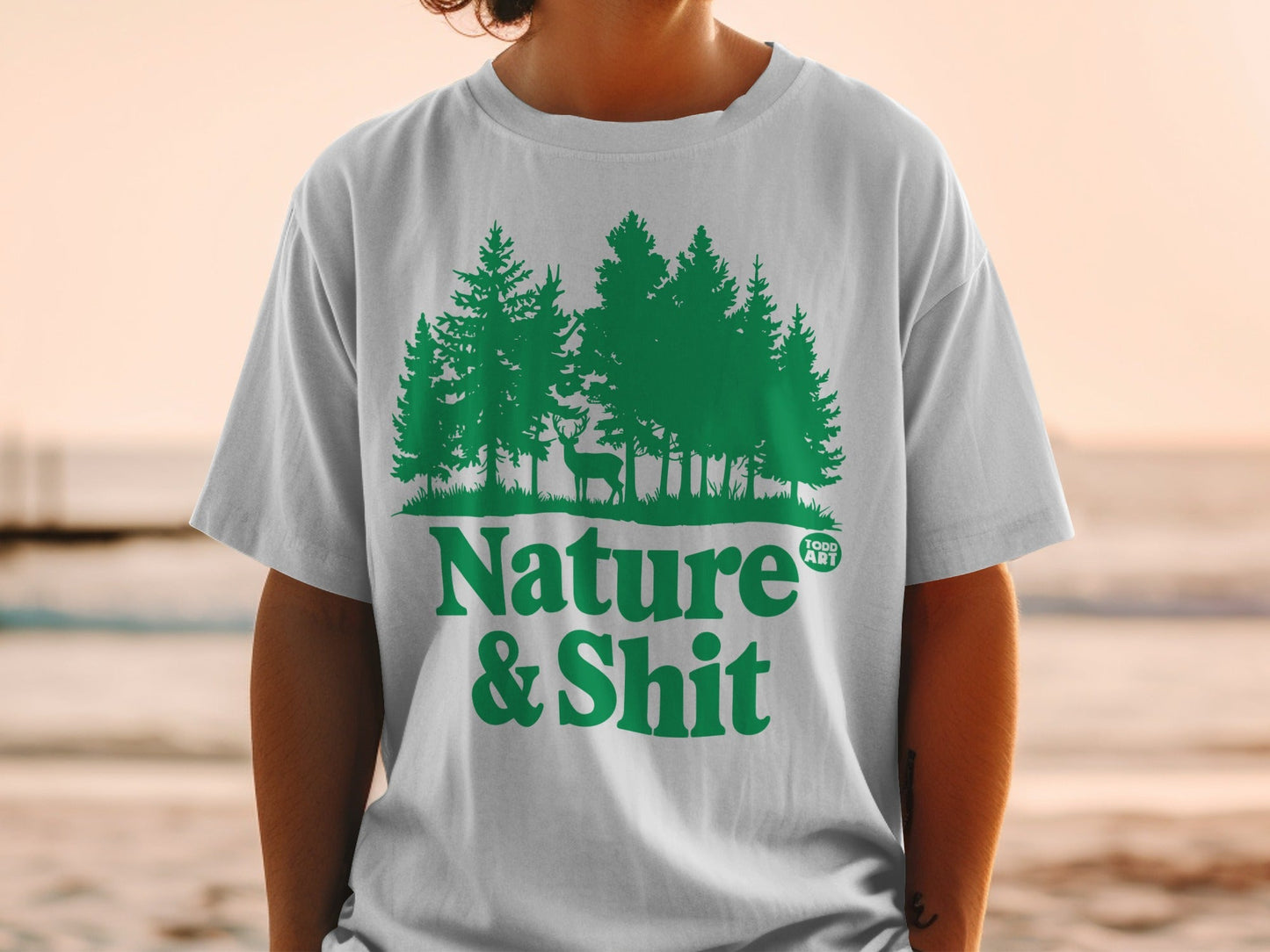White t-shirt with green forest scene and "Nature & Shit" text.