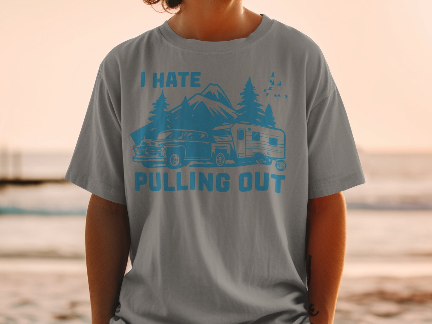 T-shirt with graphic of vintage car, camper, and mountains saying "I Hate Pulling Out".
