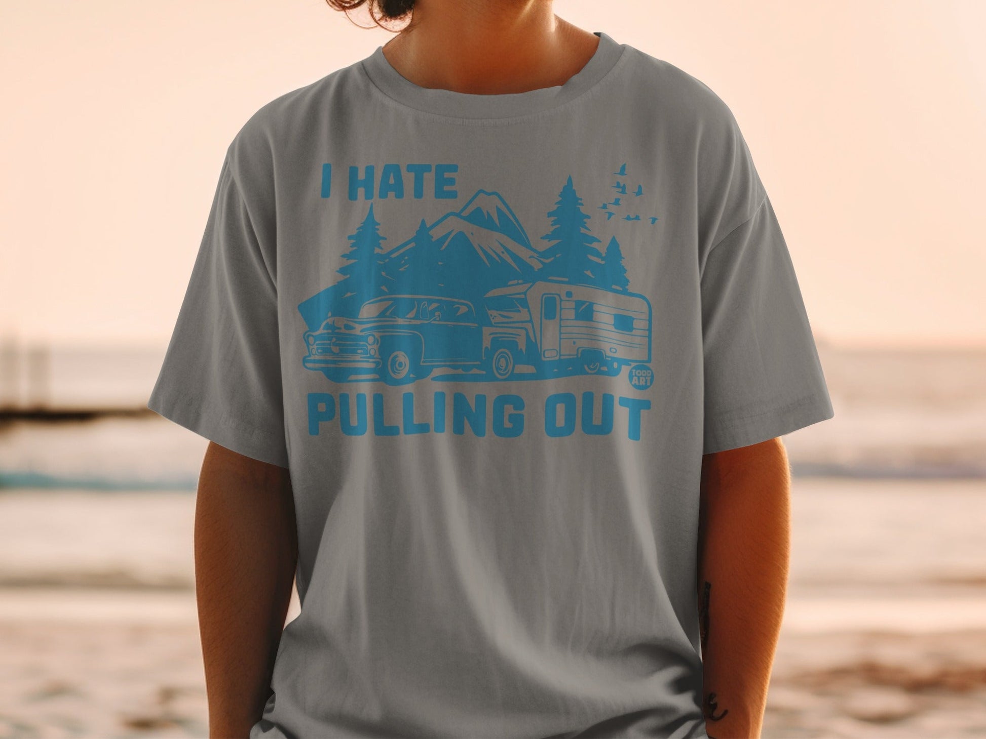 T-shirt with graphic of vintage car, camper, and mountains saying "I Hate Pulling Out".