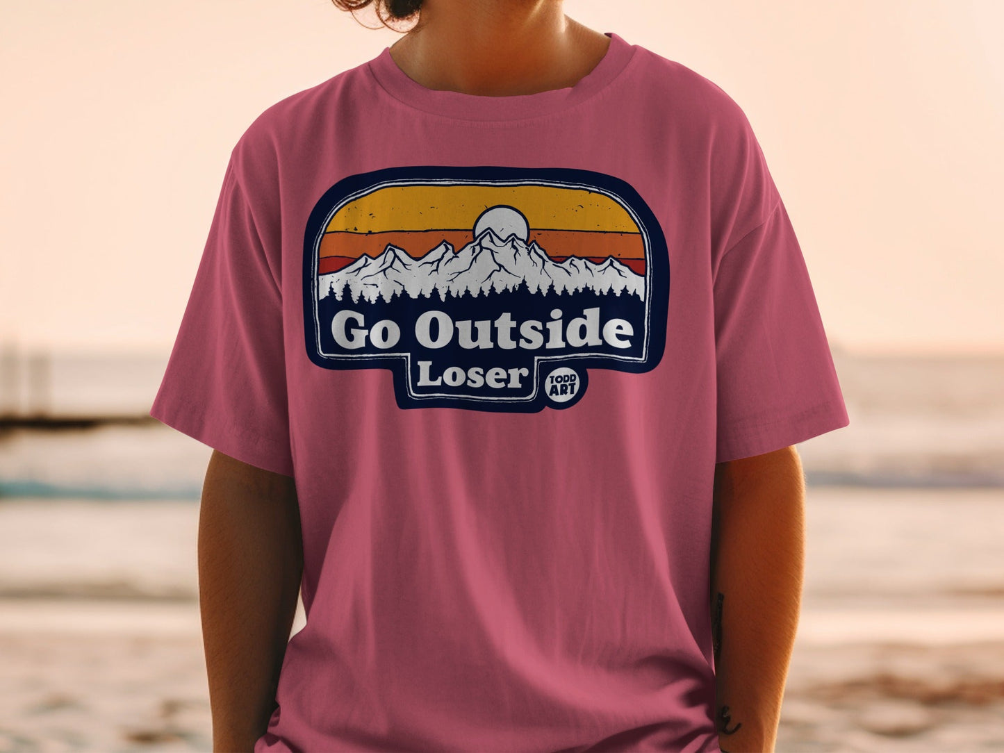 T-shirt with "Go Outside Loser" text and mountain sunset graphic.