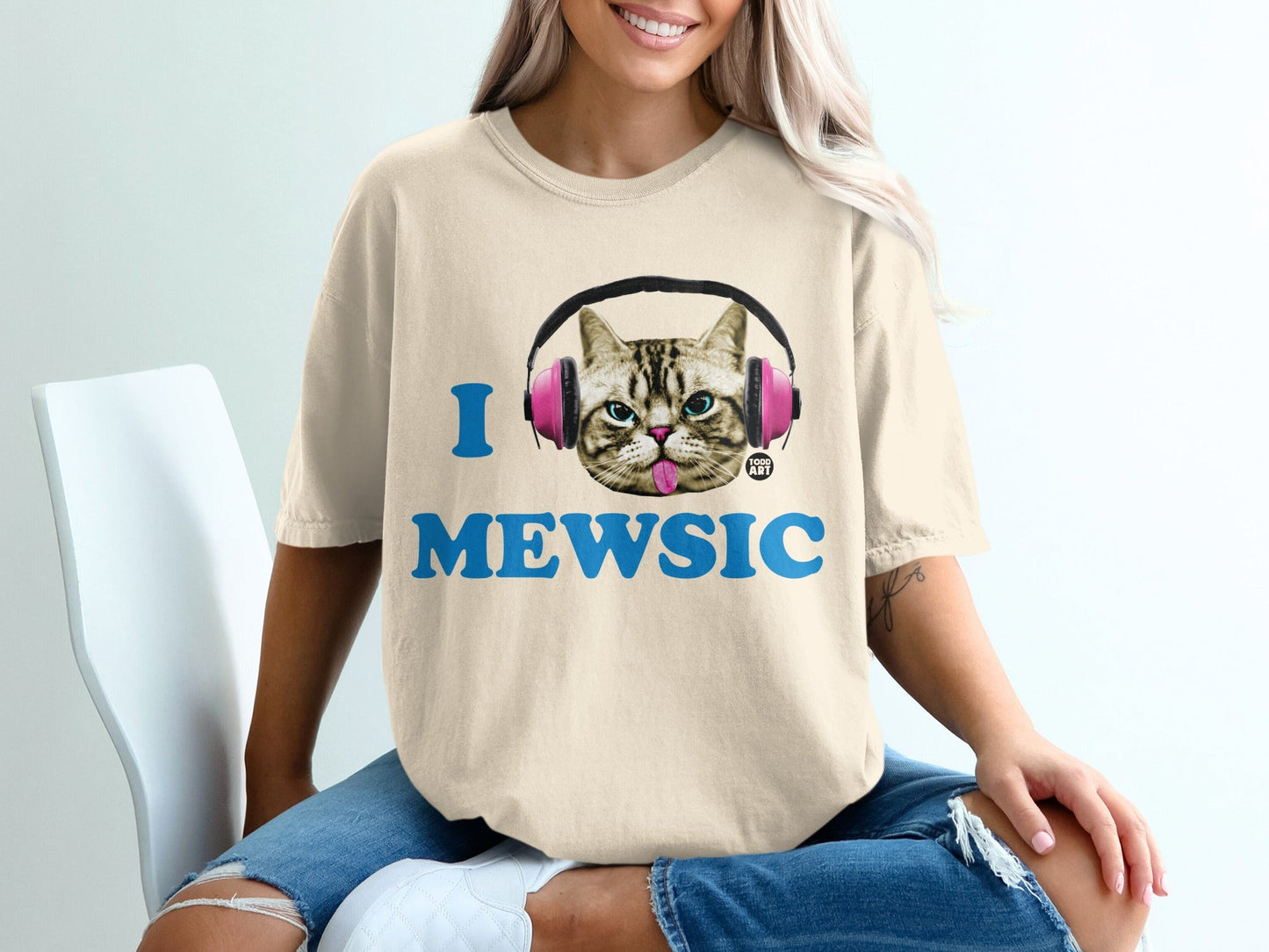 Cream t-shirt with "I MEWSIC" and a cat wearing pink headphones.