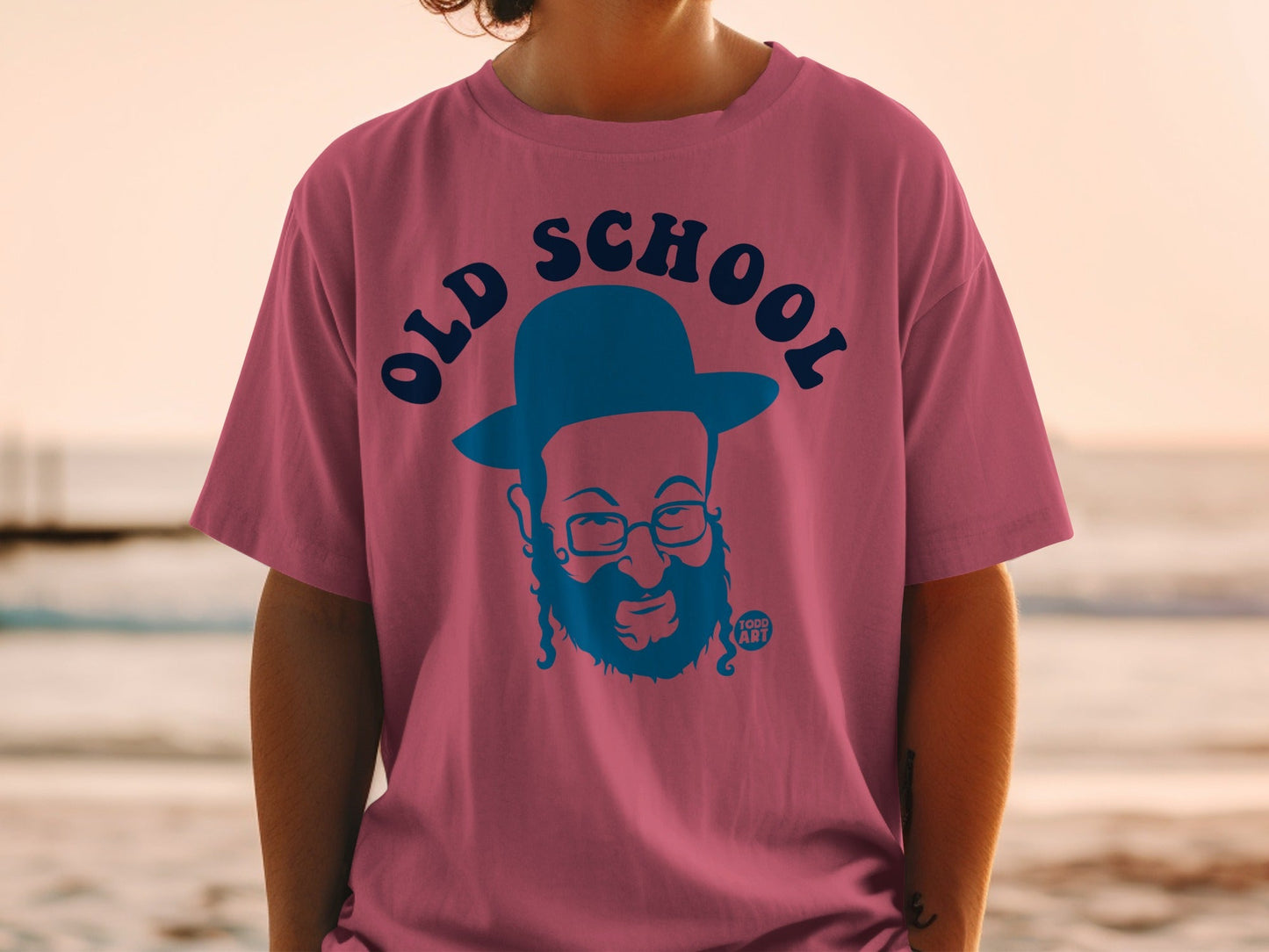 Pink t-shirt with blue "Old School" graphic and bearded man in a hat.