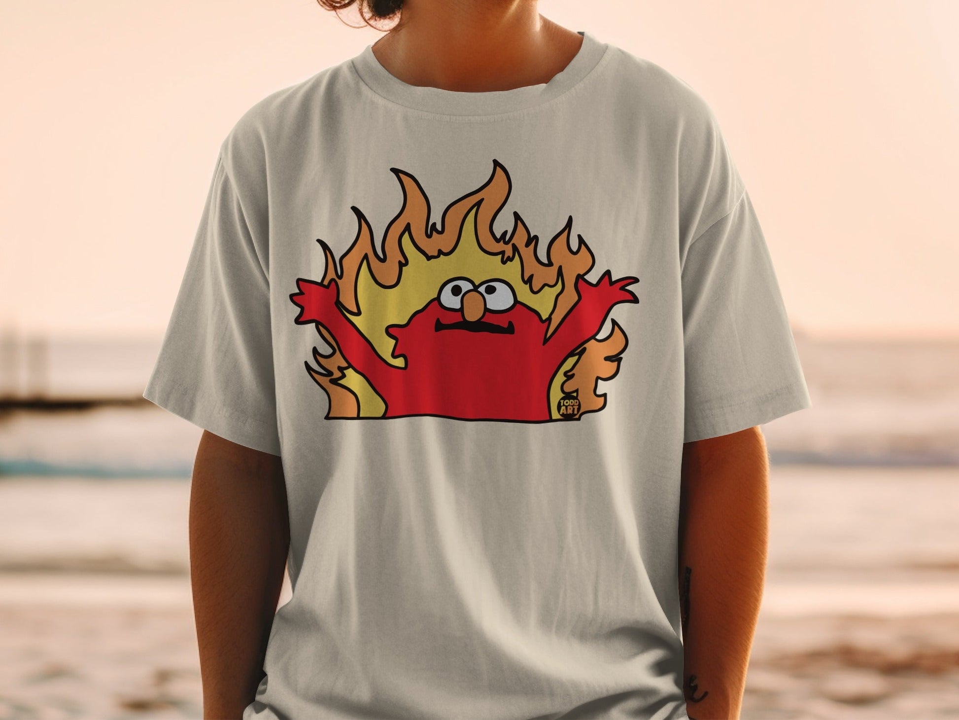 Elmo cartoon character on a t-shirt with flames around him.