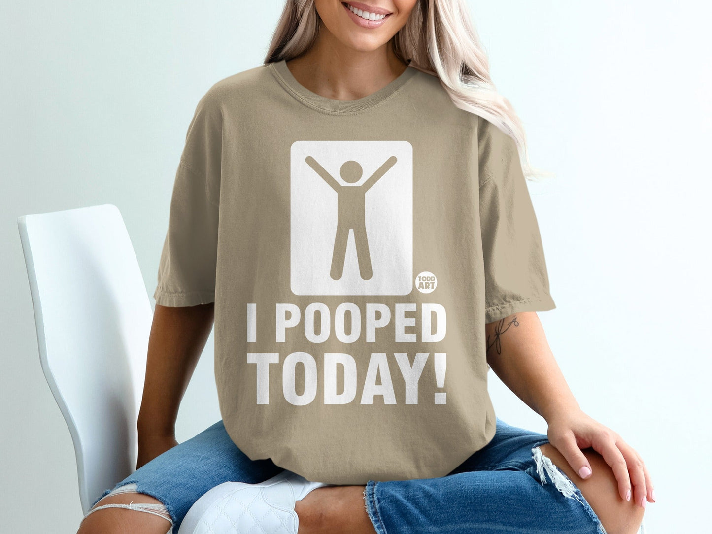 Tan t-shirt with white graphic of person raising arms and text "I POOPED TODAY!"