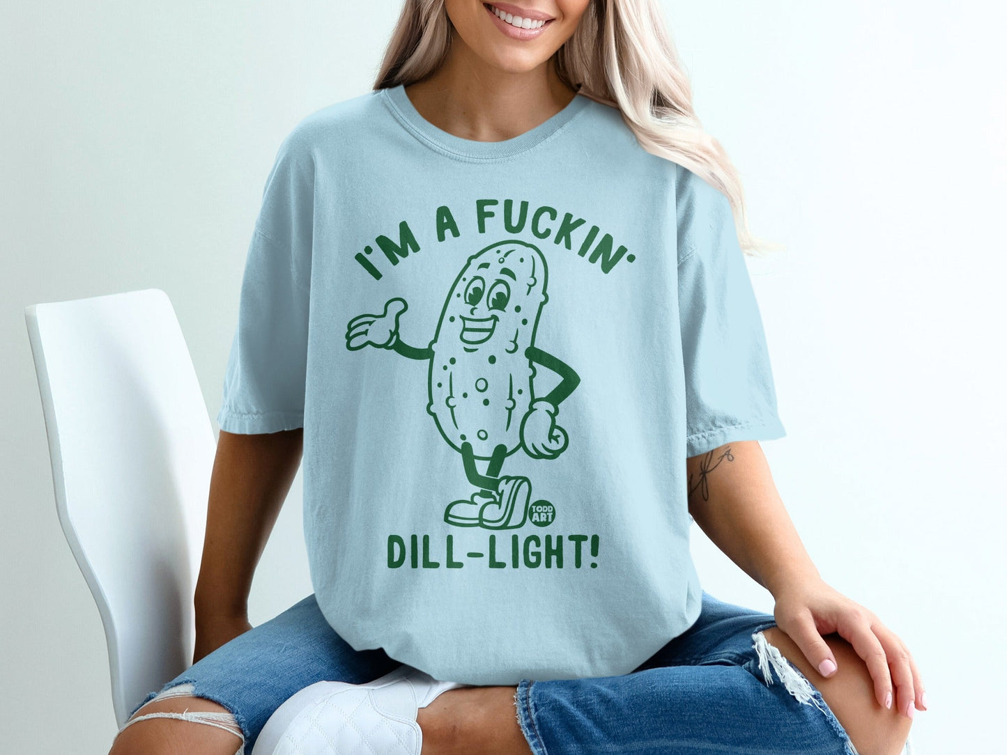 Light blue t-shirt with a cartoon pickle saying "I'm a fuckin' dill-light!"