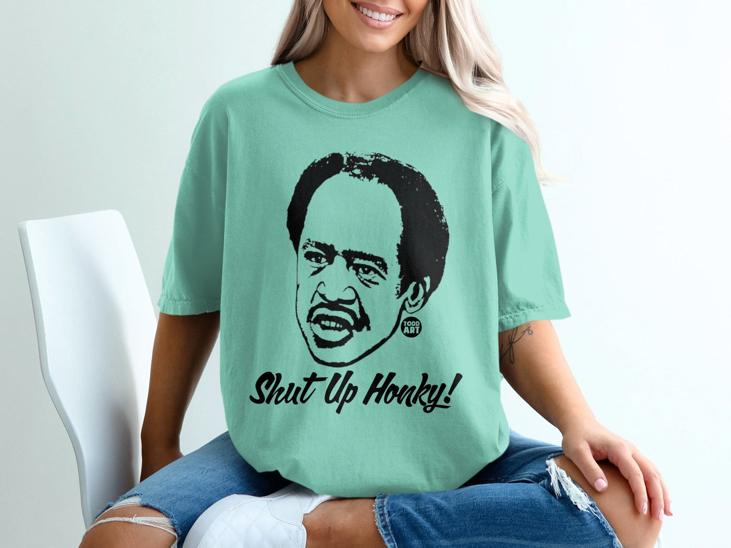 Teal t-shirt with black graphic of Richard Pryor and "Shut Up Honky!" text.