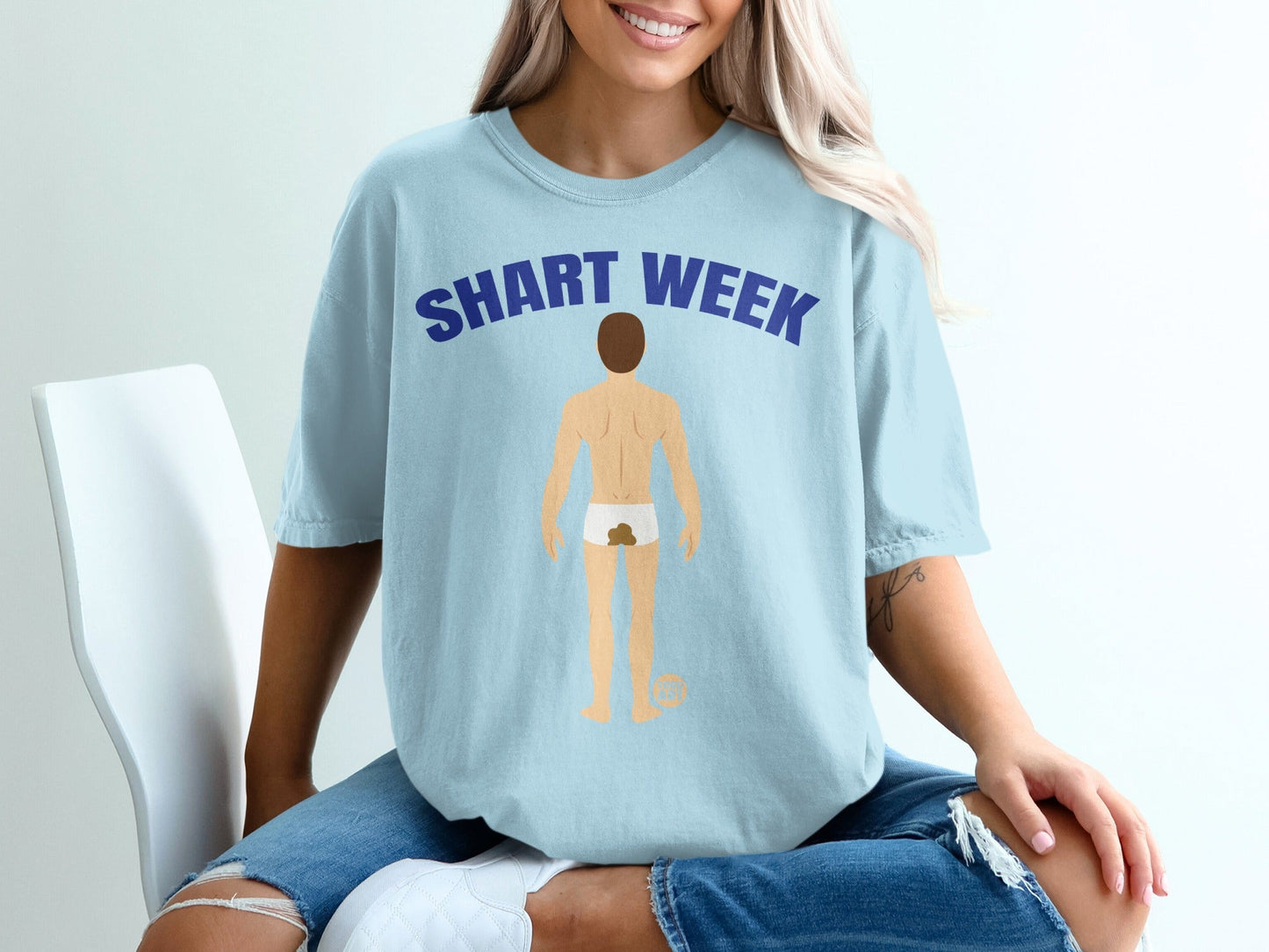 Light blue t-shirt with "SHART WEEK" text and cartoon man graphic.