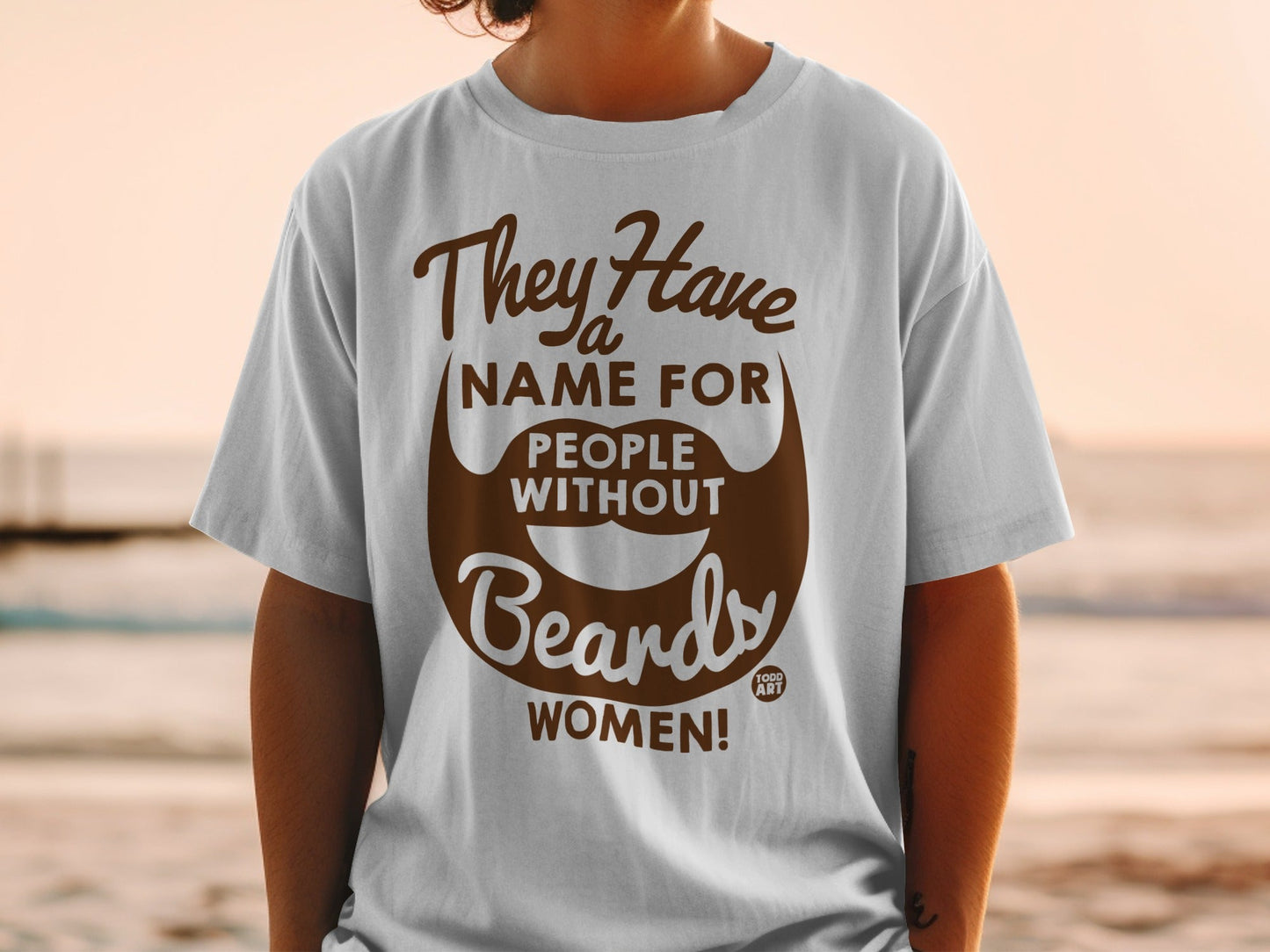White t-shirt with brown text and beard graphic: "They Have Name For People Without Beards WOMEN!"