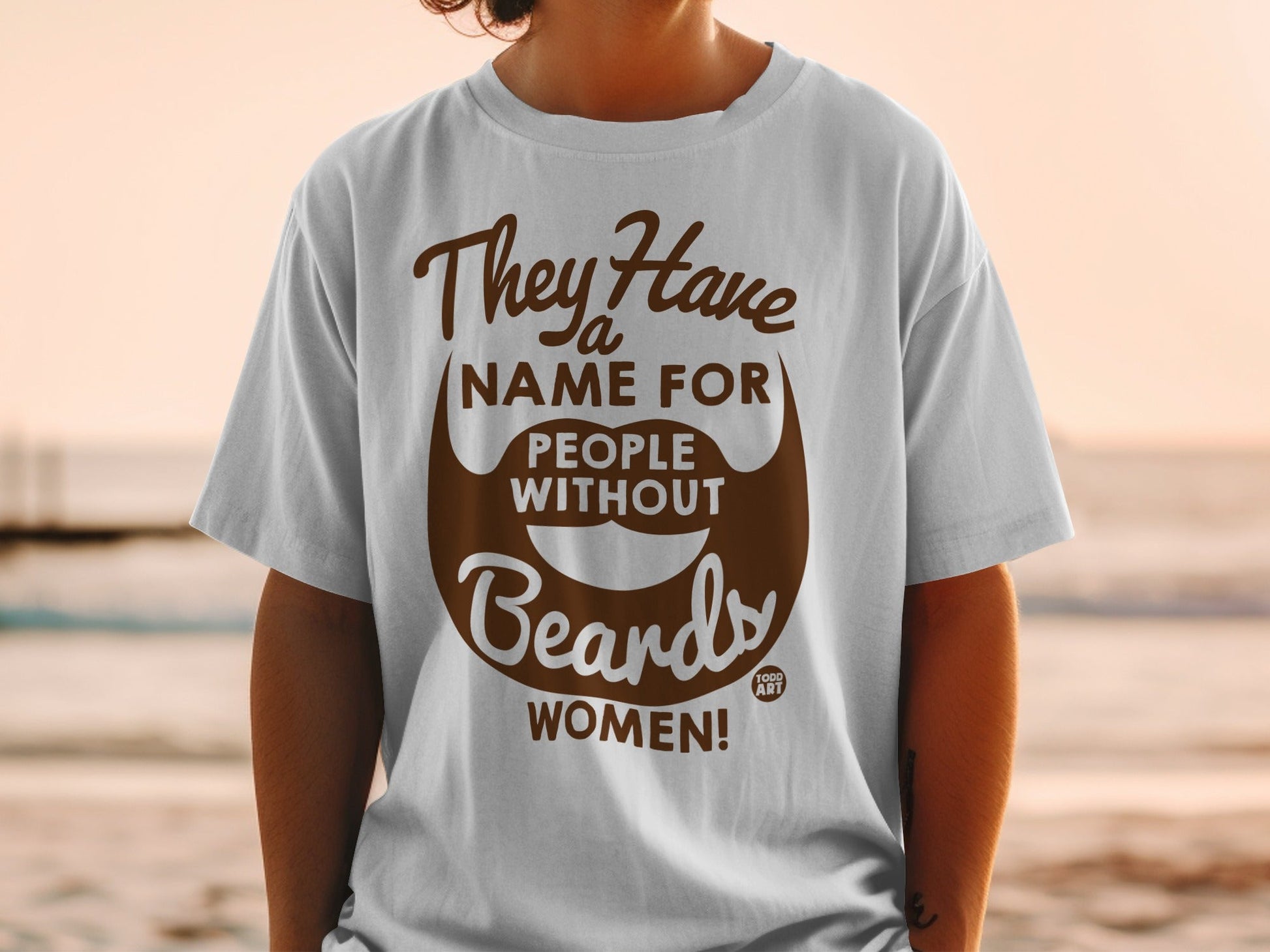 White t-shirt with brown text and beard graphic: "They Have Name For People Without Beards WOMEN!"