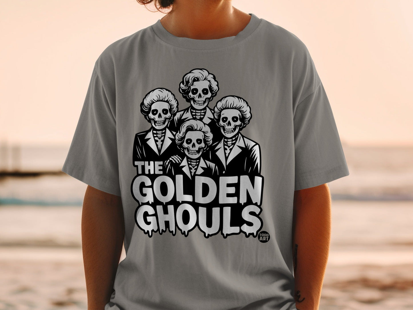T-shirt with cartoon skeletons in suits and "The Golden Ghouls" text.