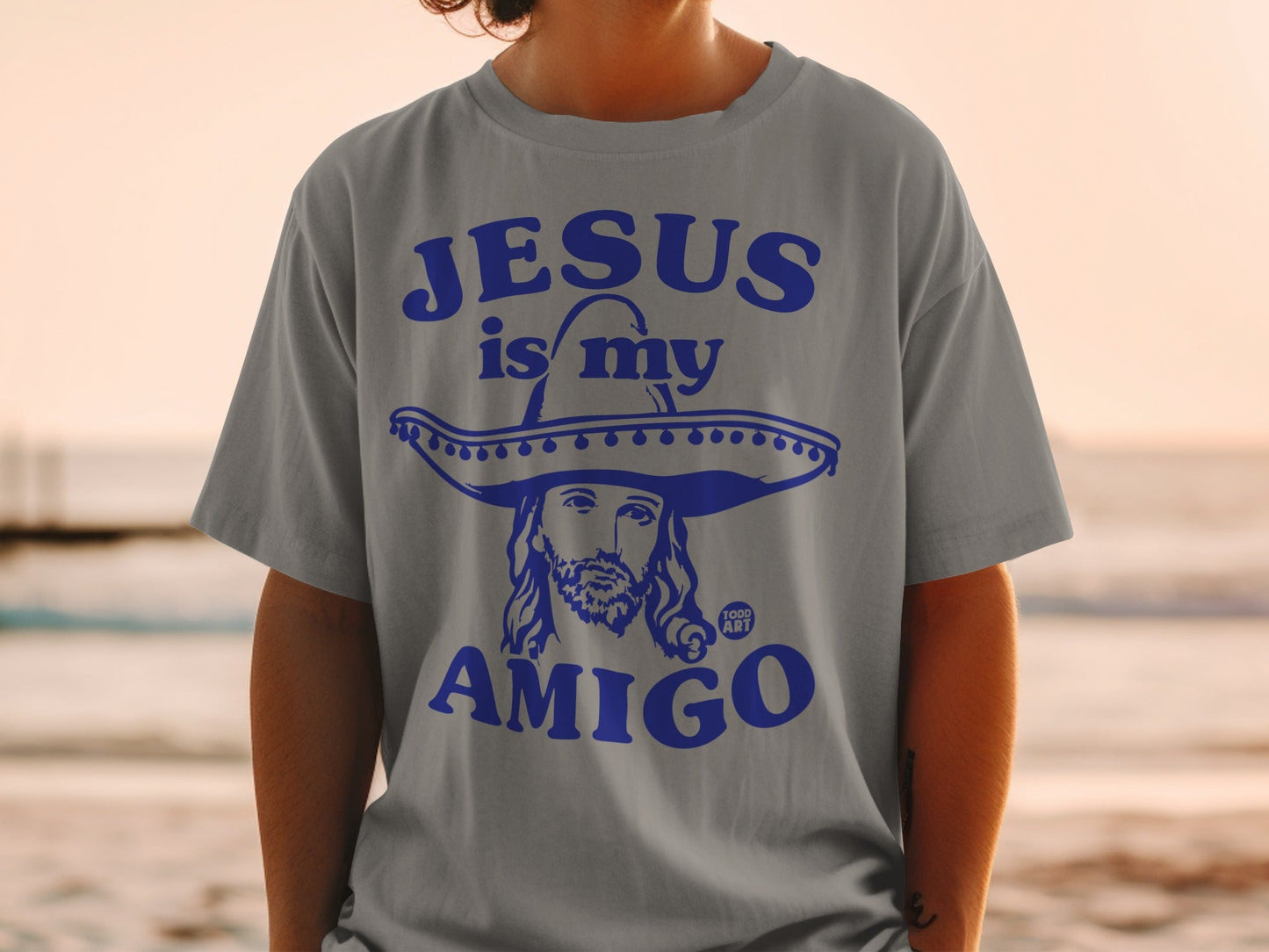 Grey t-shirt with "Jesus is my Amigo" text and sombrero-wearing Jesus graphic.
