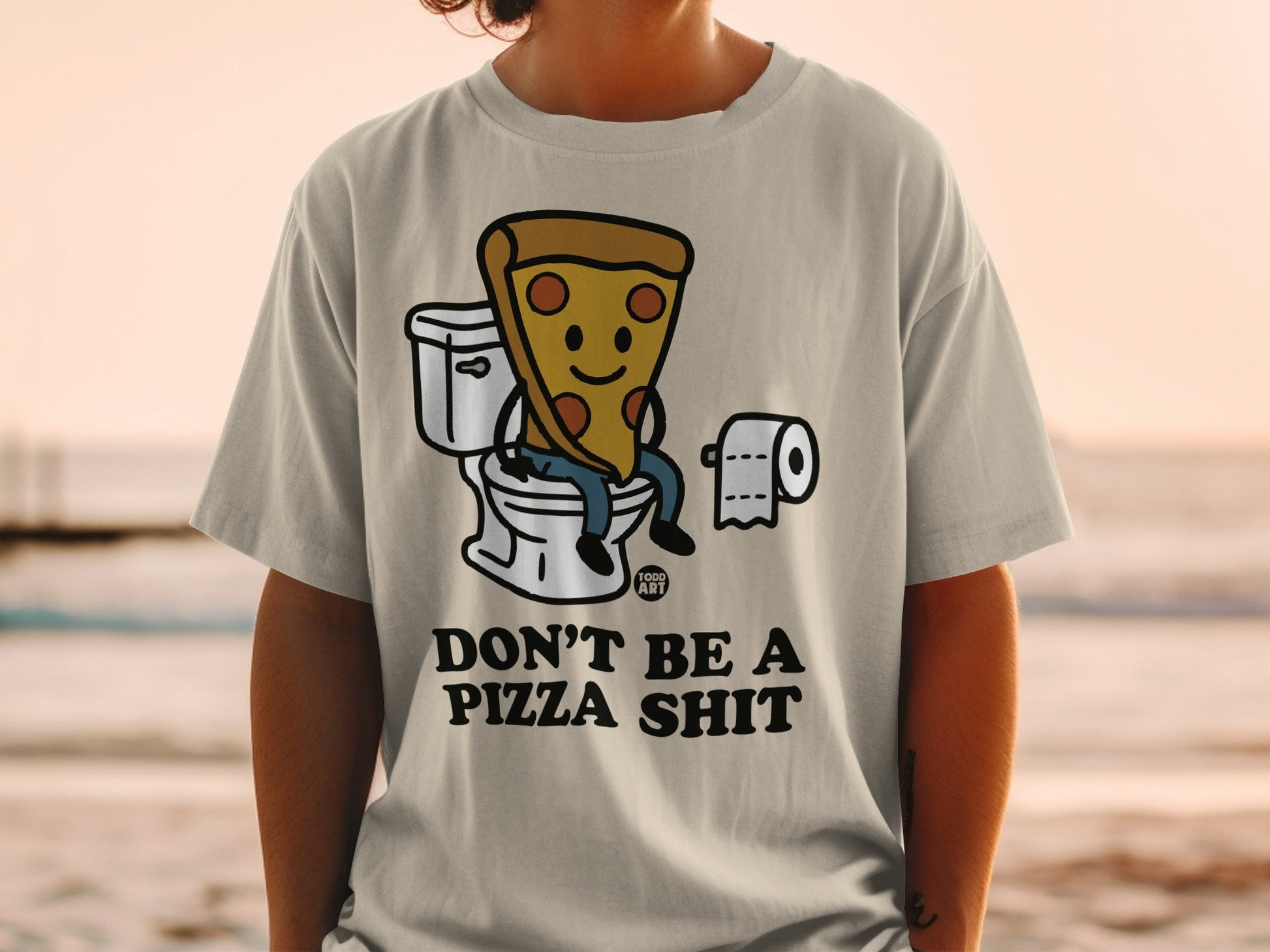 T-shirt with cartoon pizza slice sitting on toilet, text "DON'T BE A PIZZA SHIT".