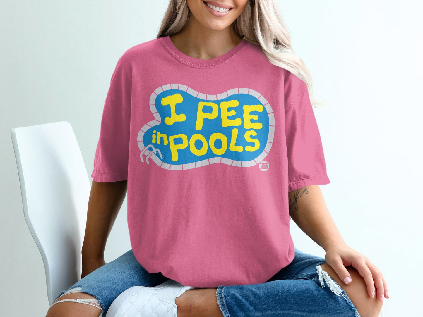 Pink t-shirt with blue "I pee in pools" text in a pool shape.